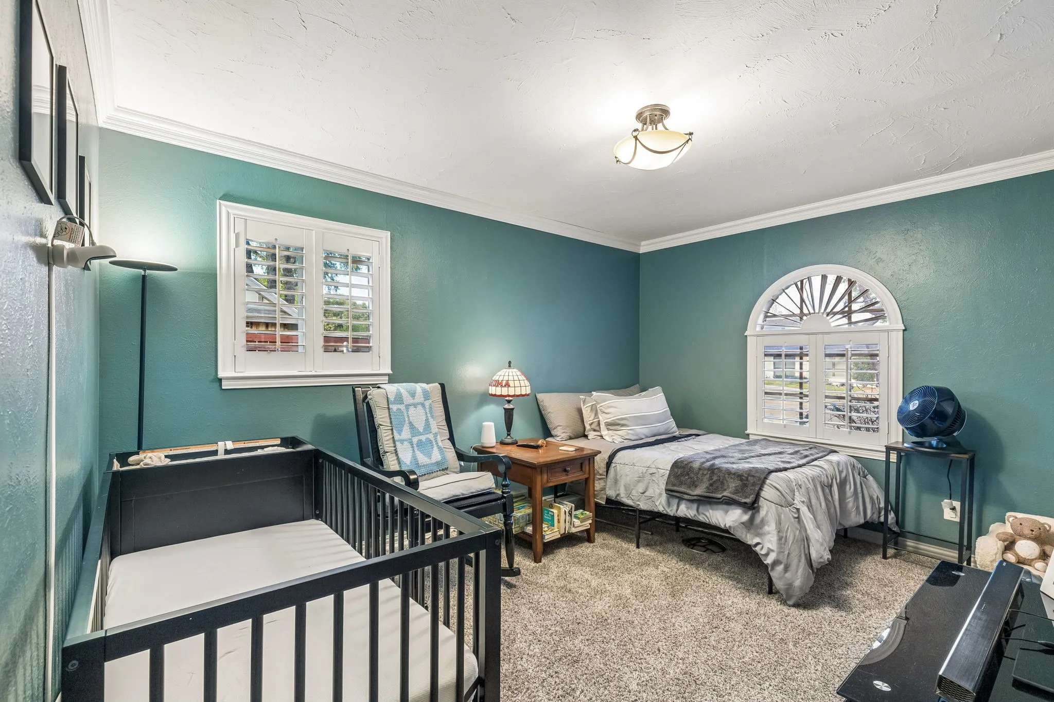 Bedroom featuring carpet flooring, multiple windows, crown molding, a textured wall, and a textured ceiling