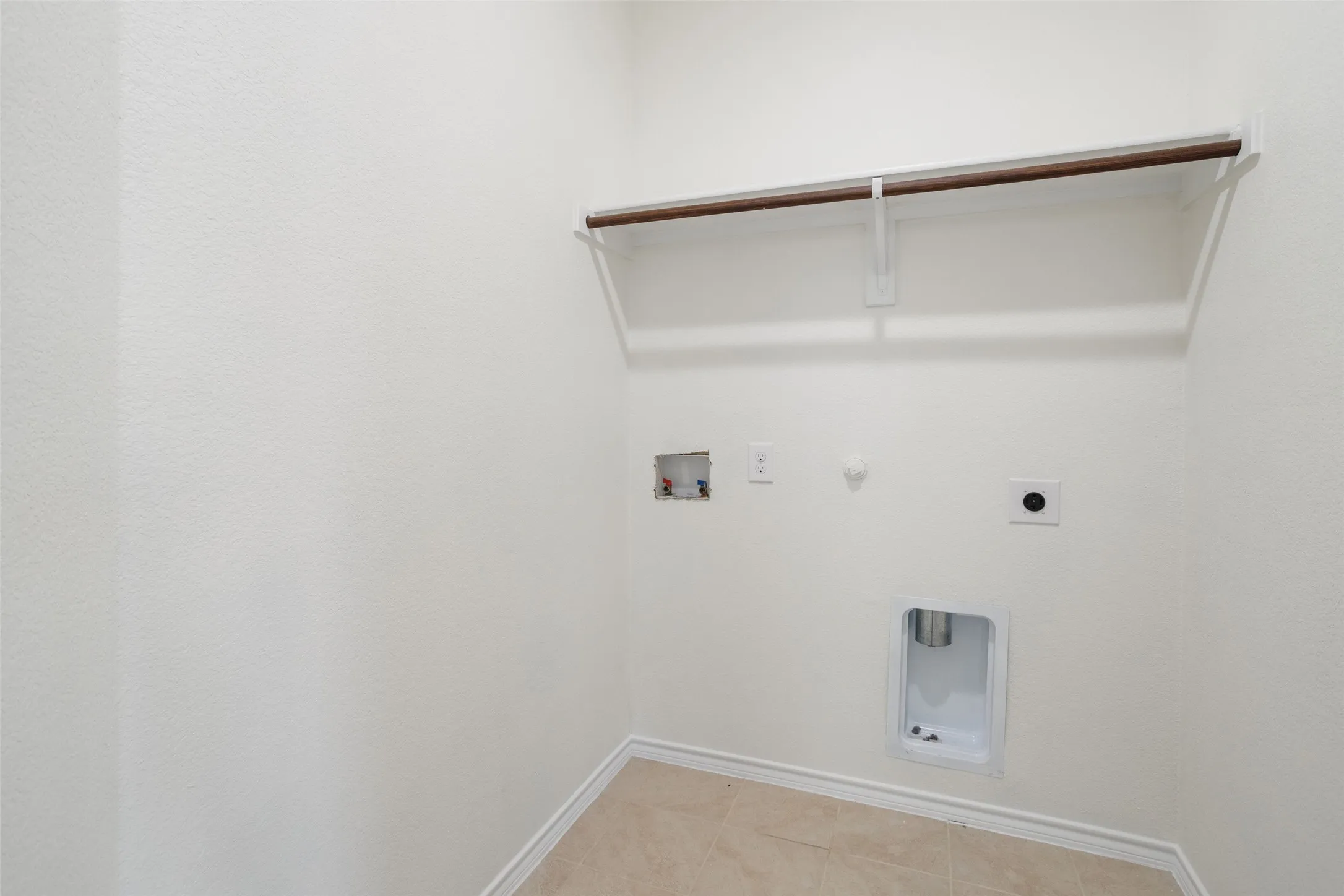 Clothes washing area with hookup for an electric dryer, hookup for a gas dryer, tile floors, and hookup for a washing machine