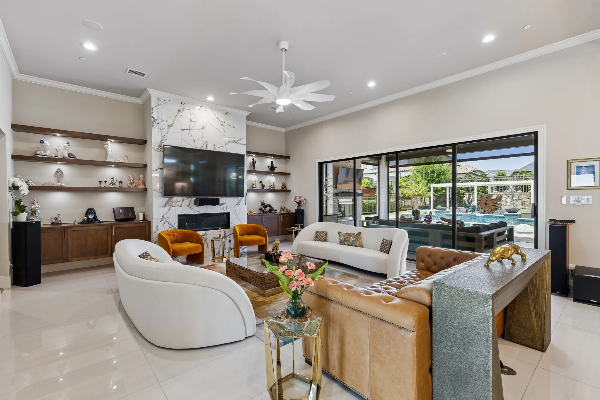 The living room is anchored by a floor-to-ceiling fireplace and floating built-ins with integrated 11.1 surround sound.