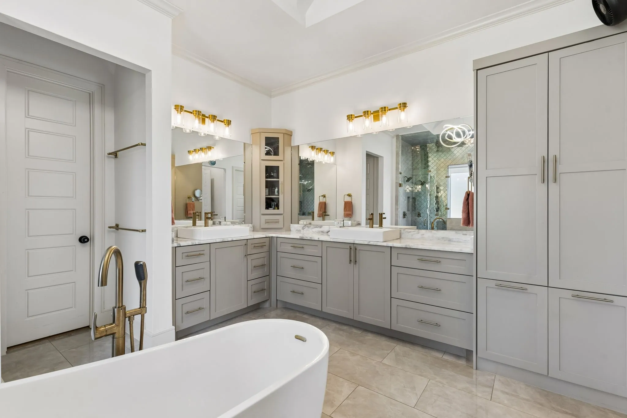 Gorgeous bathroom with dual sinks, linen cabinet, his and hers closets, soaking tub, and dual head shower system.