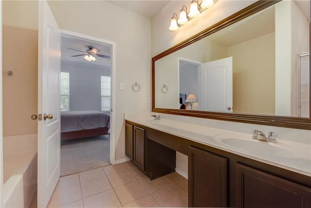 Dual vanity with a white countertop and dark wood-finish cabinetry