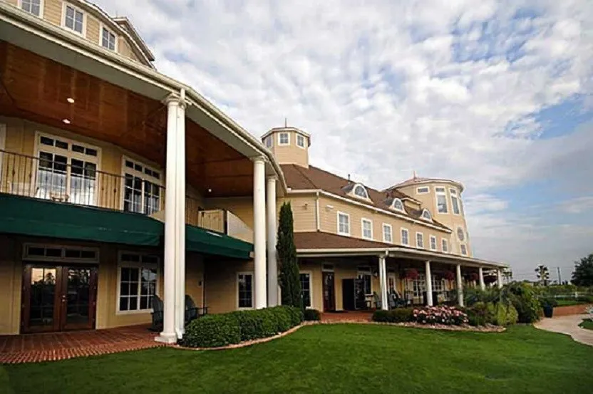 Brick facade residence featuring a covered entry porch, dark wood-finish front door, and decorative wood-finish window shutters.