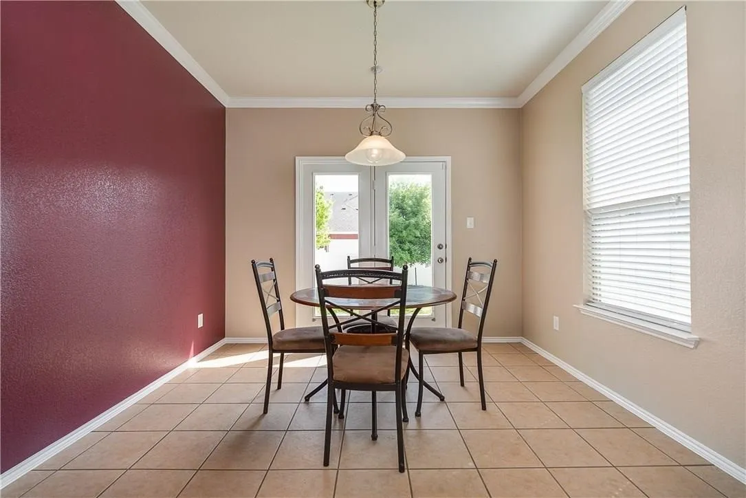 STAGED - Breakfast area feature maroon paint, decorative lighting and views of the backyard.