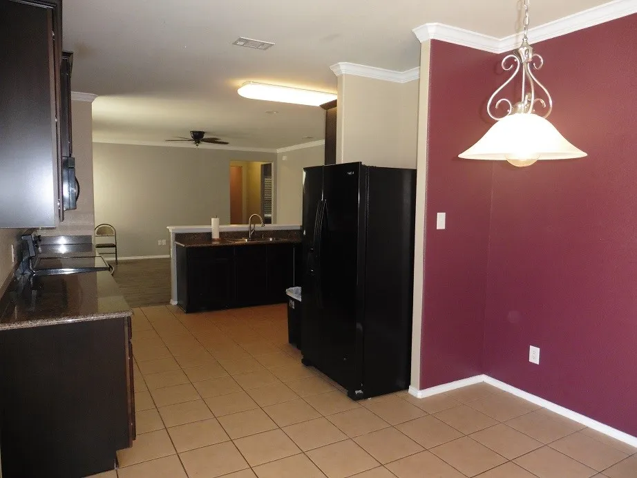 Breakfast area feature maroon paint, decorative lighting and views of the backyard.
