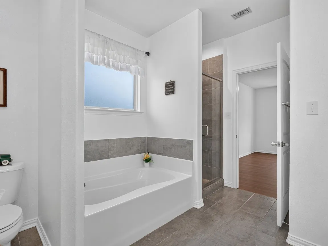 Primary bathroom with a large garden tub and separate walk-in shower.