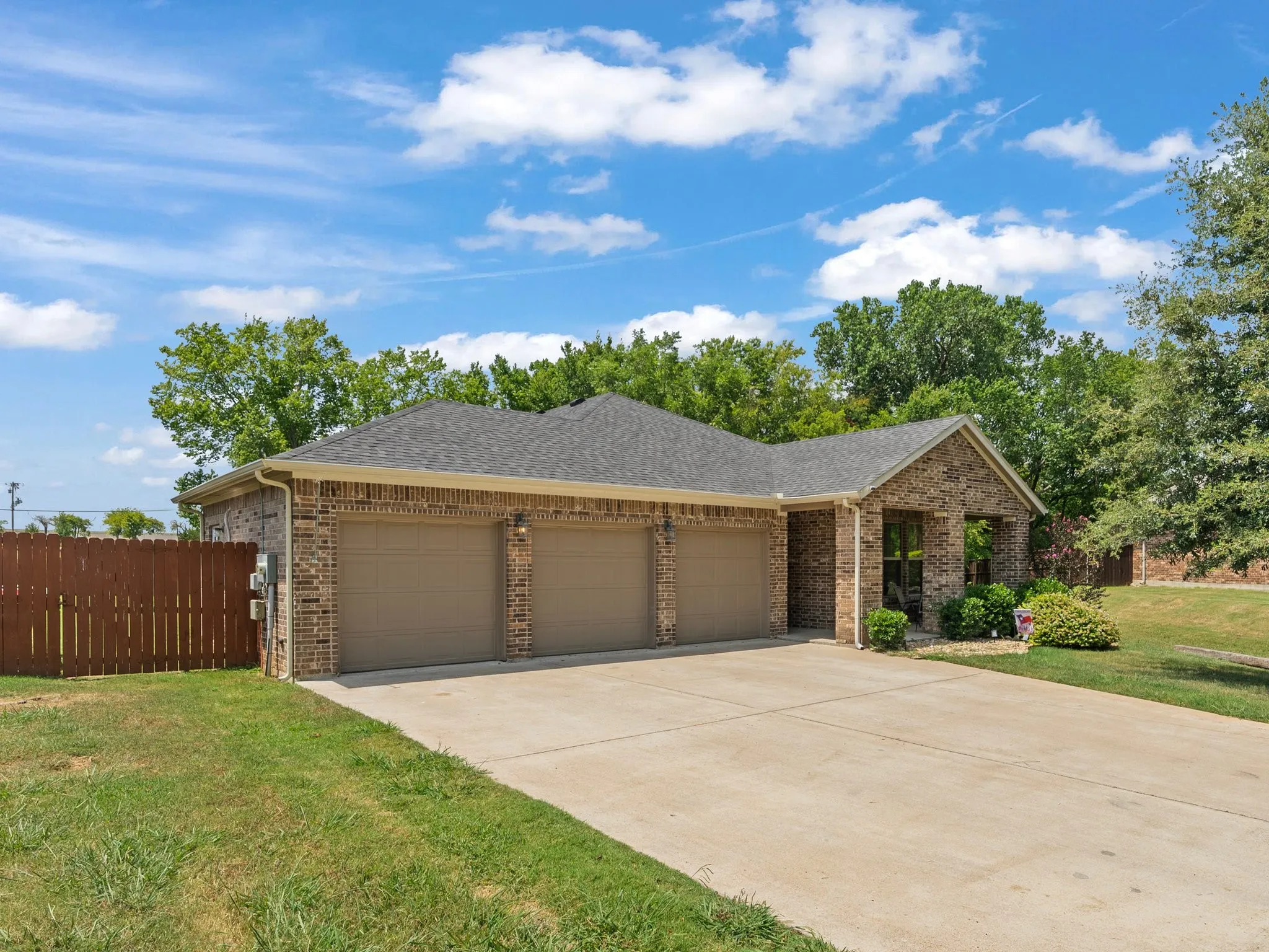 Attached front-facing 3-car garage with a mini-split heating and cooling system and extended driveway.