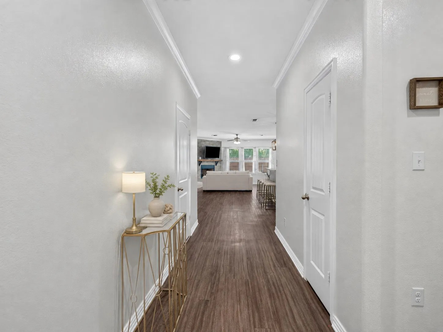 Entry hallway with luxury vinyl plank flooring leading into the open-concept living space. Virtually staged.