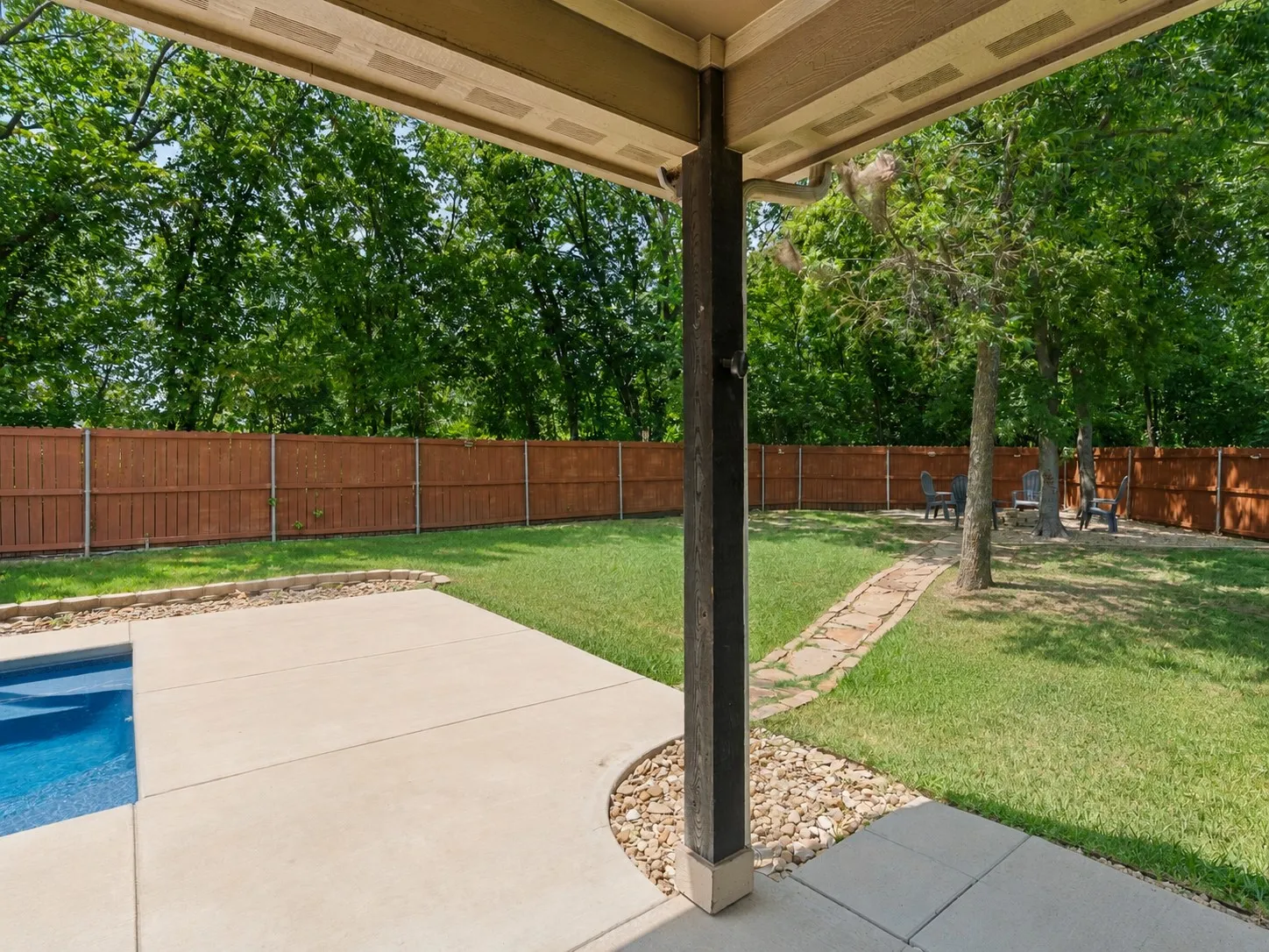 Covered patio adjoining the pool, a shaded outdoor space for dining or relaxing poolside.