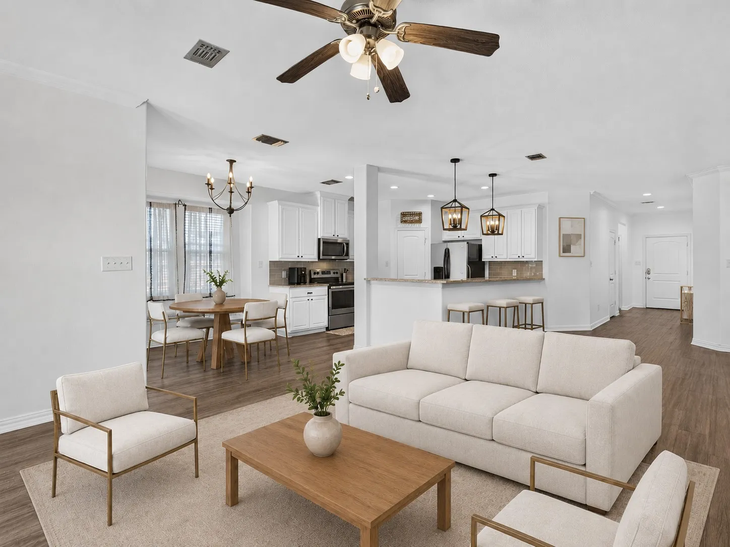 Open-concept living room flowing into the kitchen and dining areas, ideal for entertaining. Virtually staged.