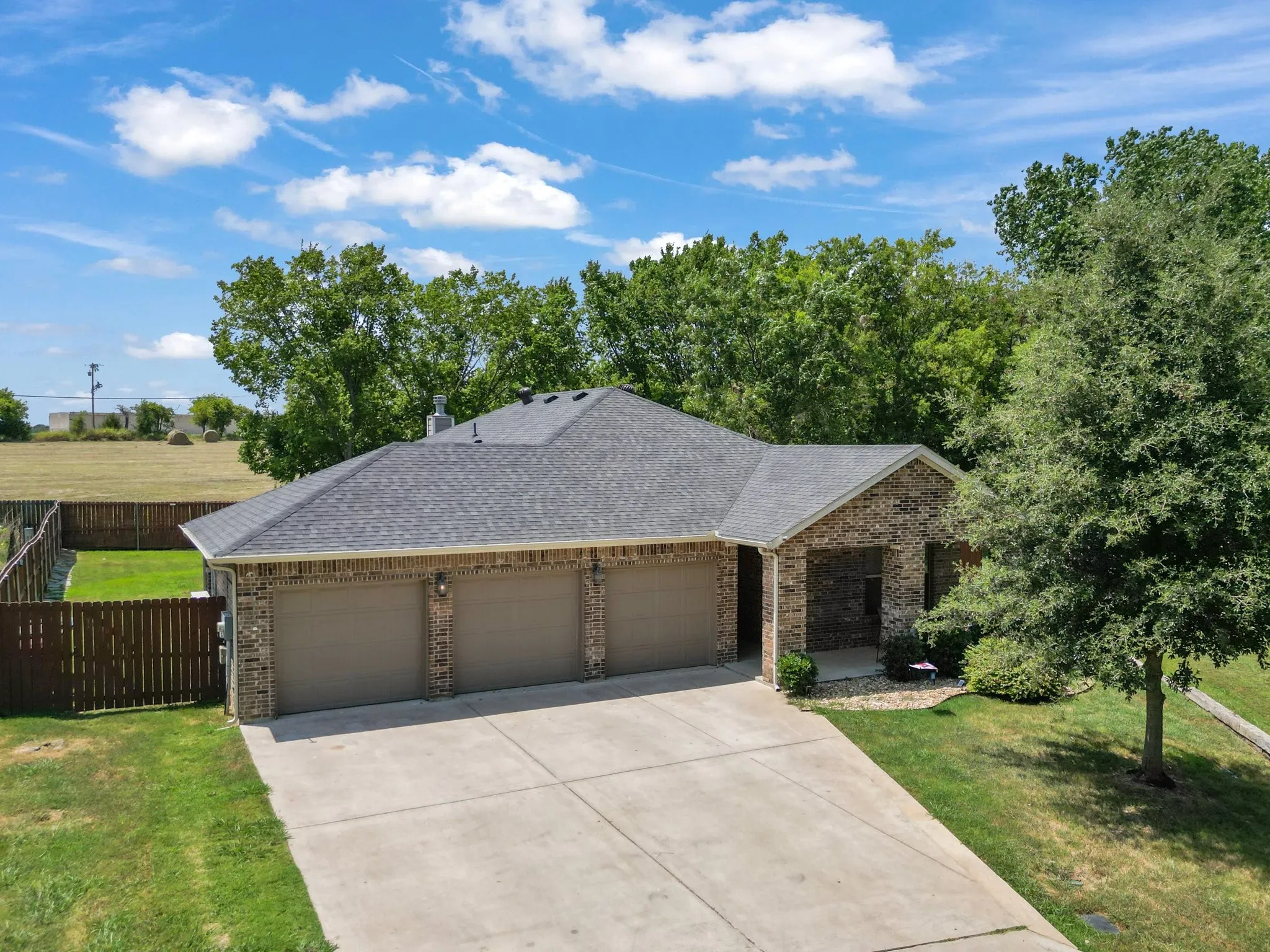 Front exterior view of the brick home with attached 3-car garage in Diamond Tee Estates, Sherman, TX.