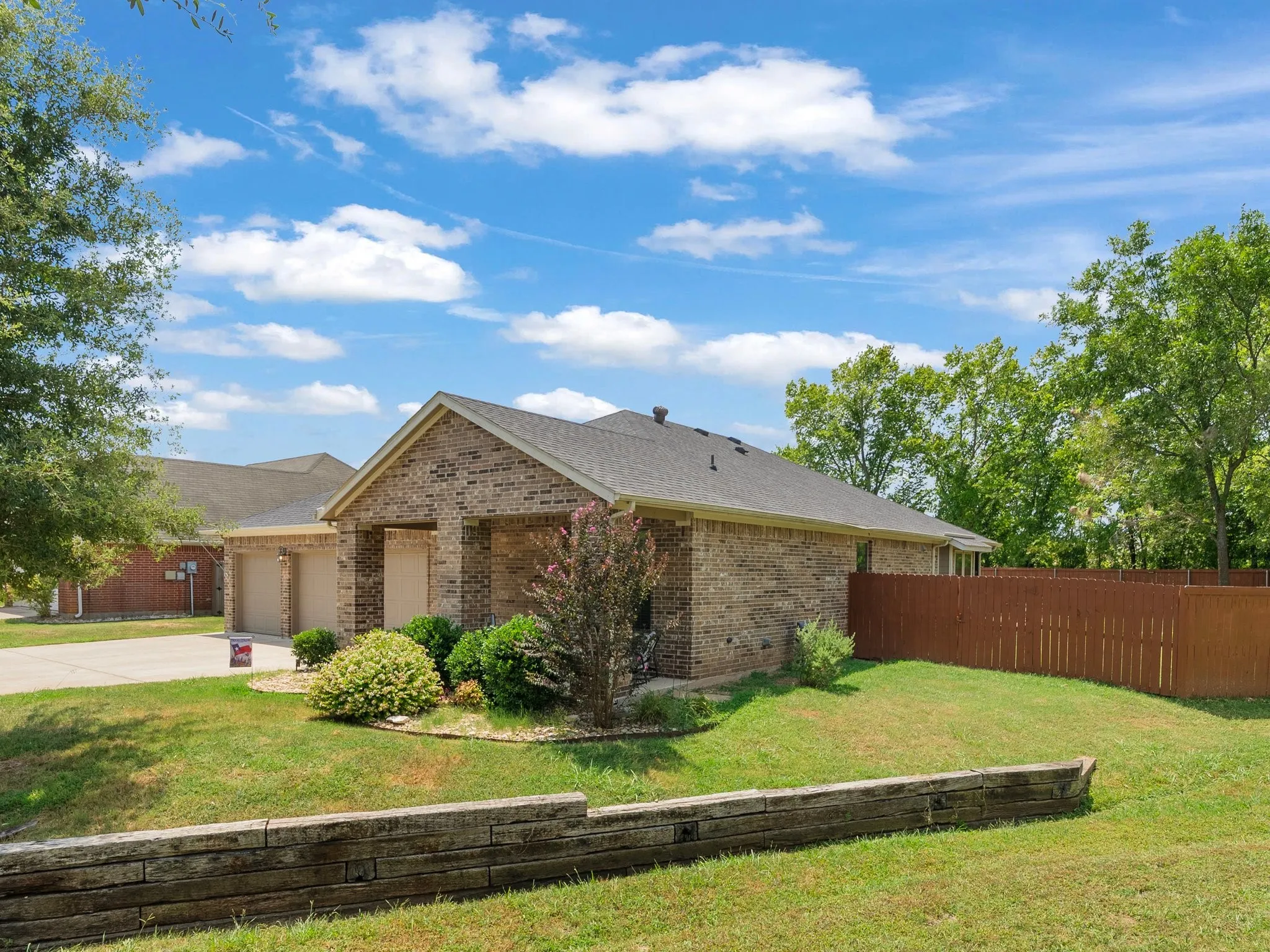 Side exterior view showing the fenced yard and mature landscaping on the 0.31-acre lot.