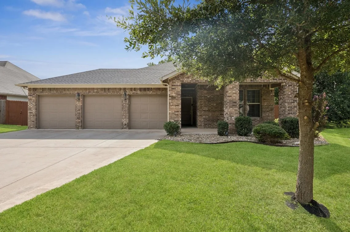 Brick single-story home in Diamond Tee Estates, Sherman TX, with attached 3-car garage and manicured front lawn.