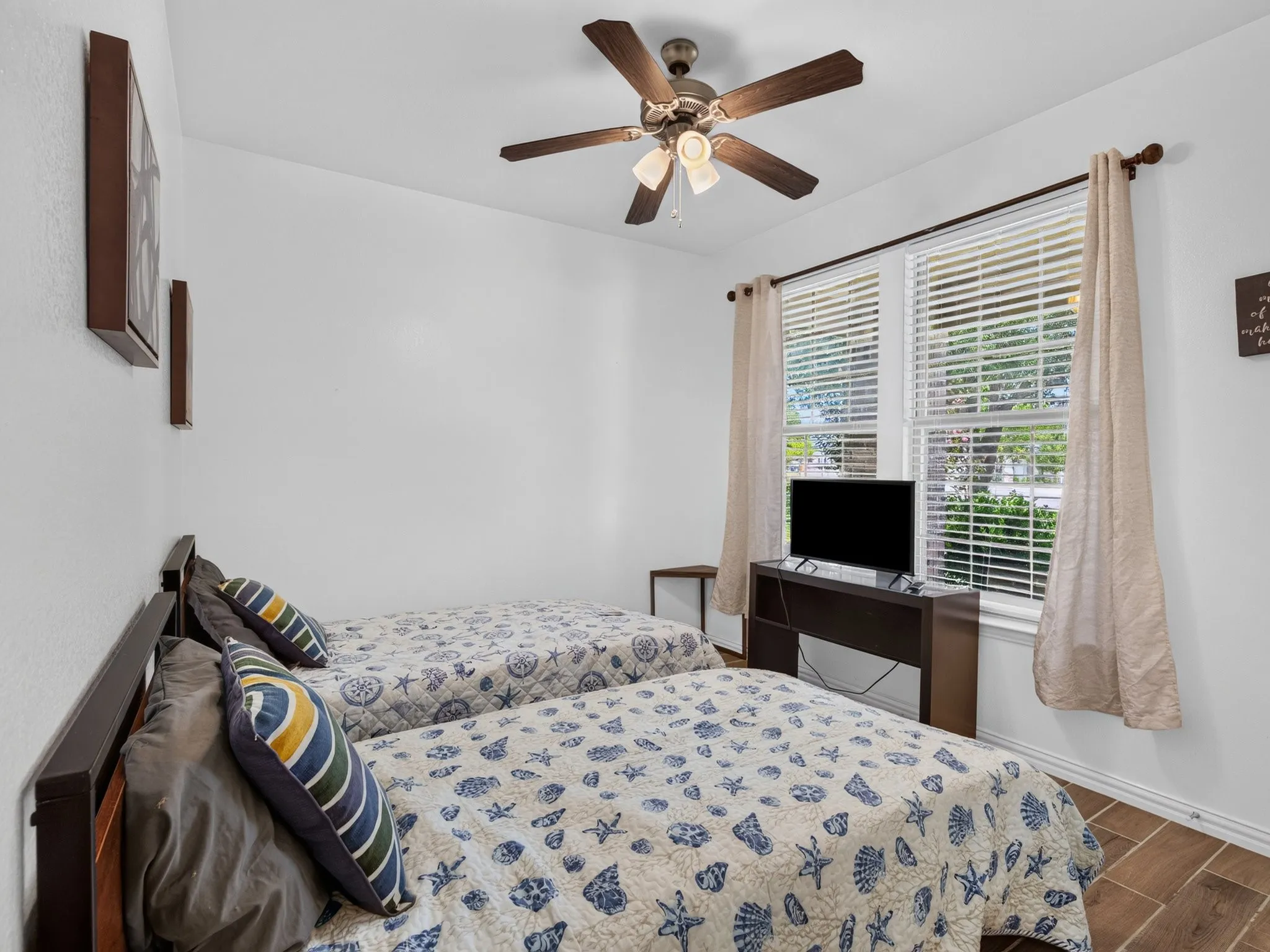Secondary bedroom with ceiling fan, located on the opposite side of the home from the primary suite.