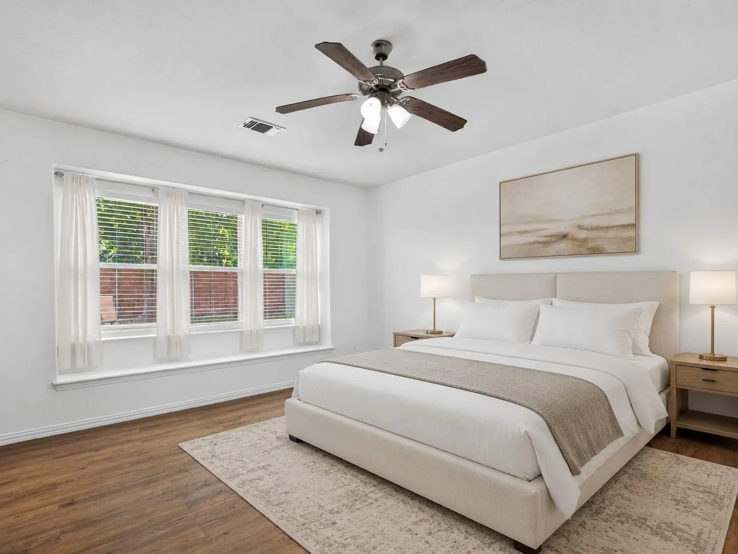 Primary bedroom with a sitting area and generous walk-in closet, set apart in the split floor plan for privacy. Virtually staged.