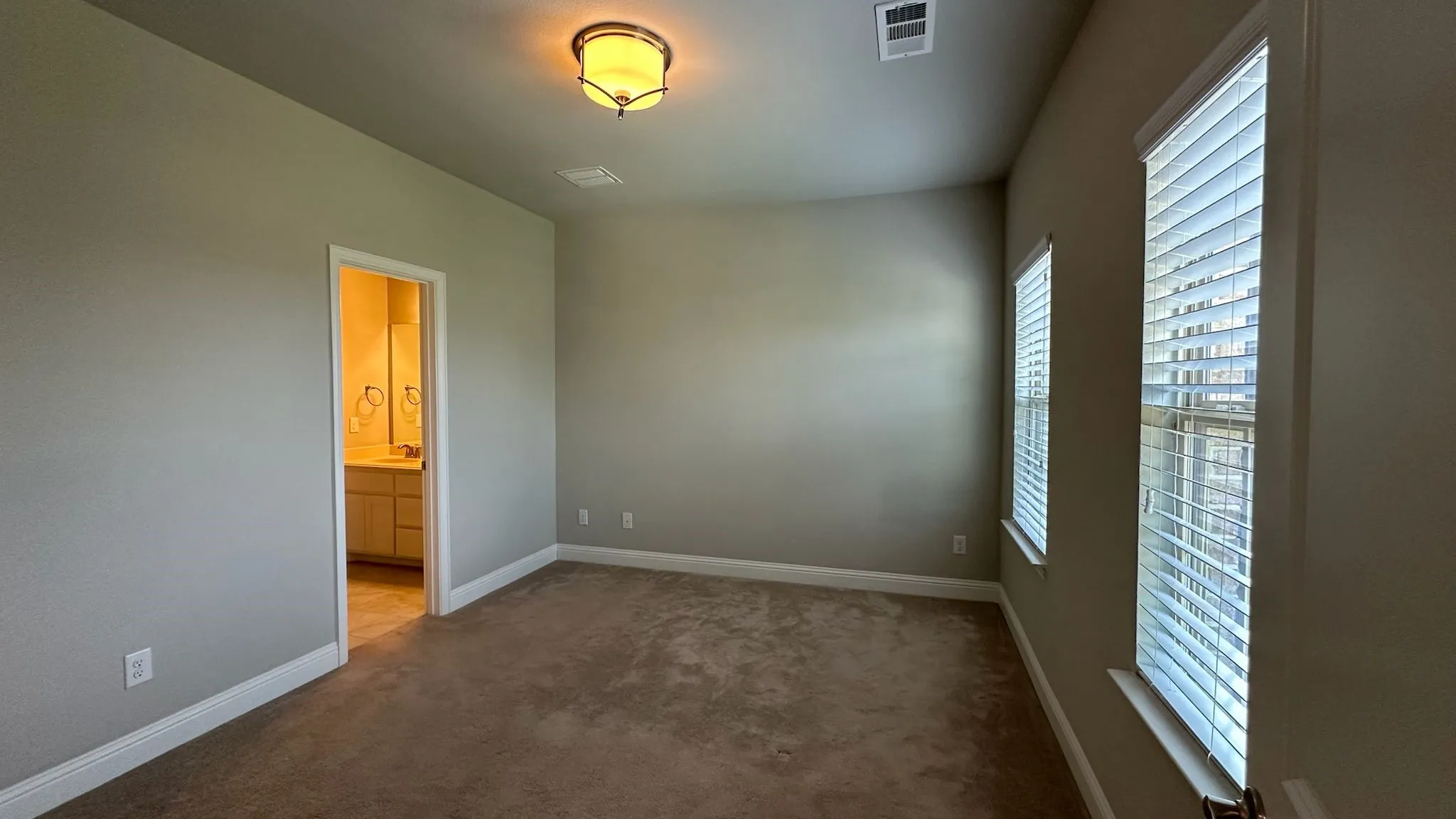 Carpeted room with neutral wall tones and a single window with blinds