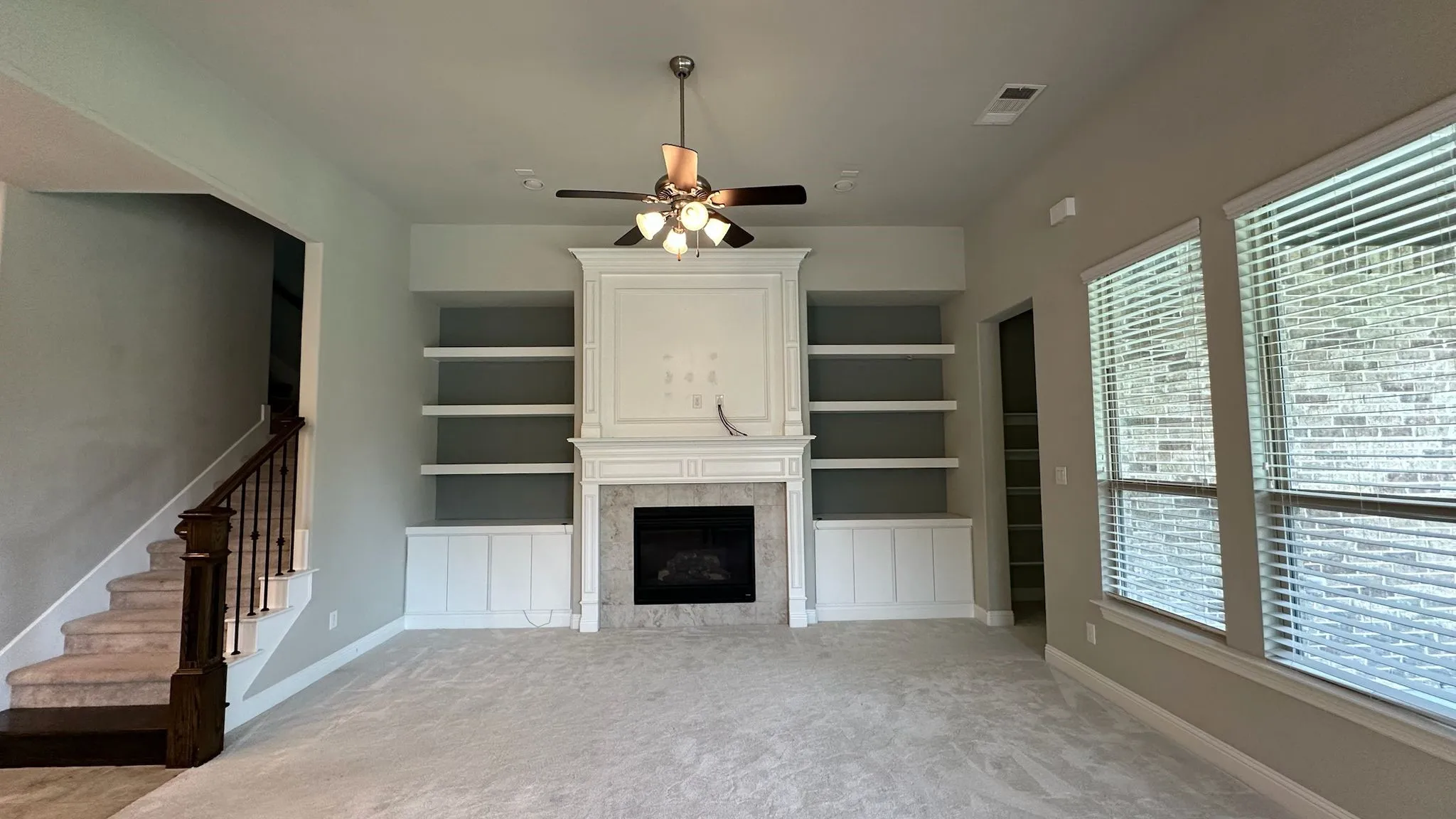 Spacious kitchen featuring white cabinetry, a large center island with a granite countertop, a tile backsplash, and stainless steel built-in appliances