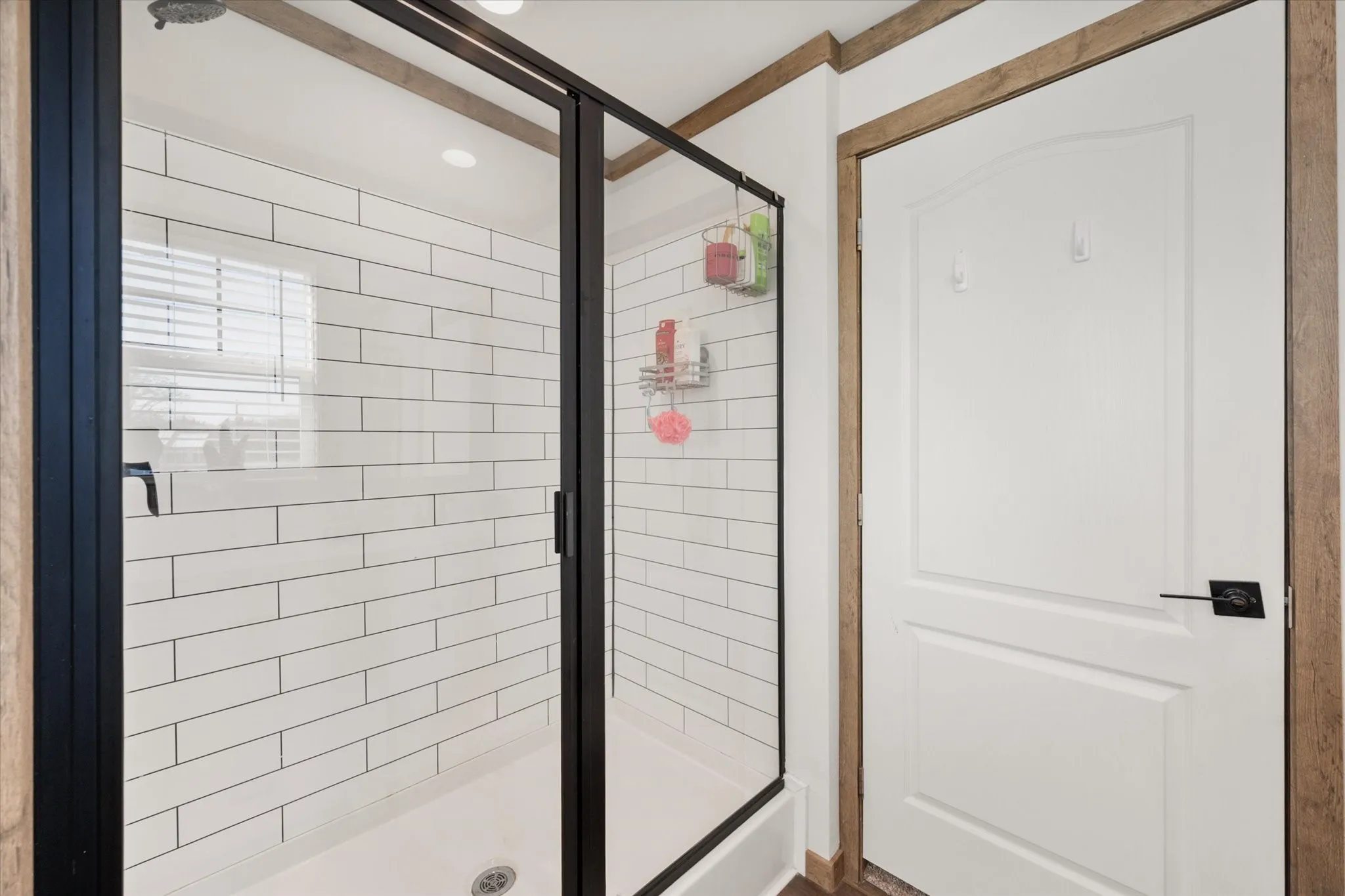 Recessed ceiling lighting, wood-finish flooring, and a glass-paneled built-in display cabinet