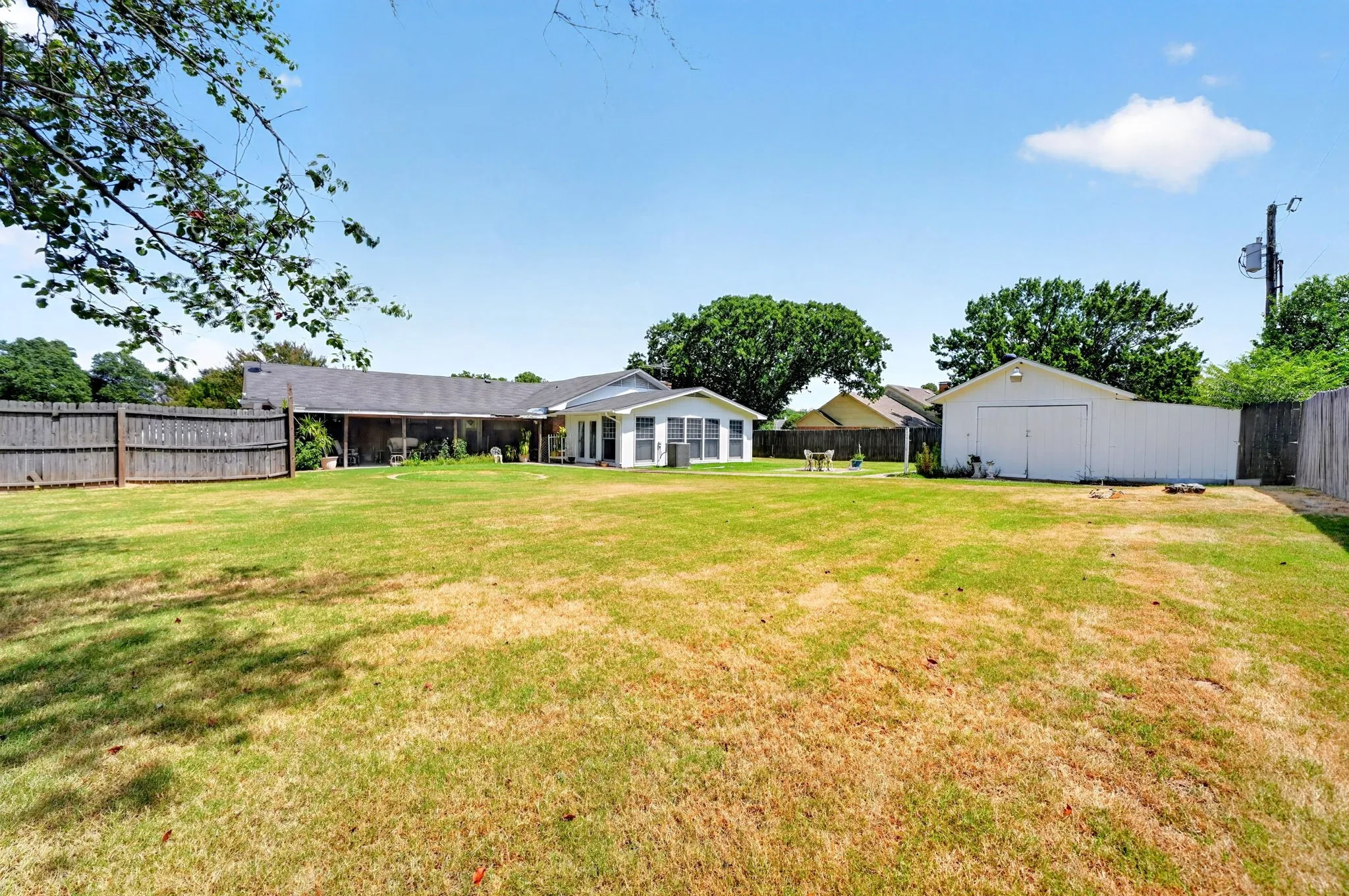 Expansive backyard featuring a detached storage building and wood privacy fencing