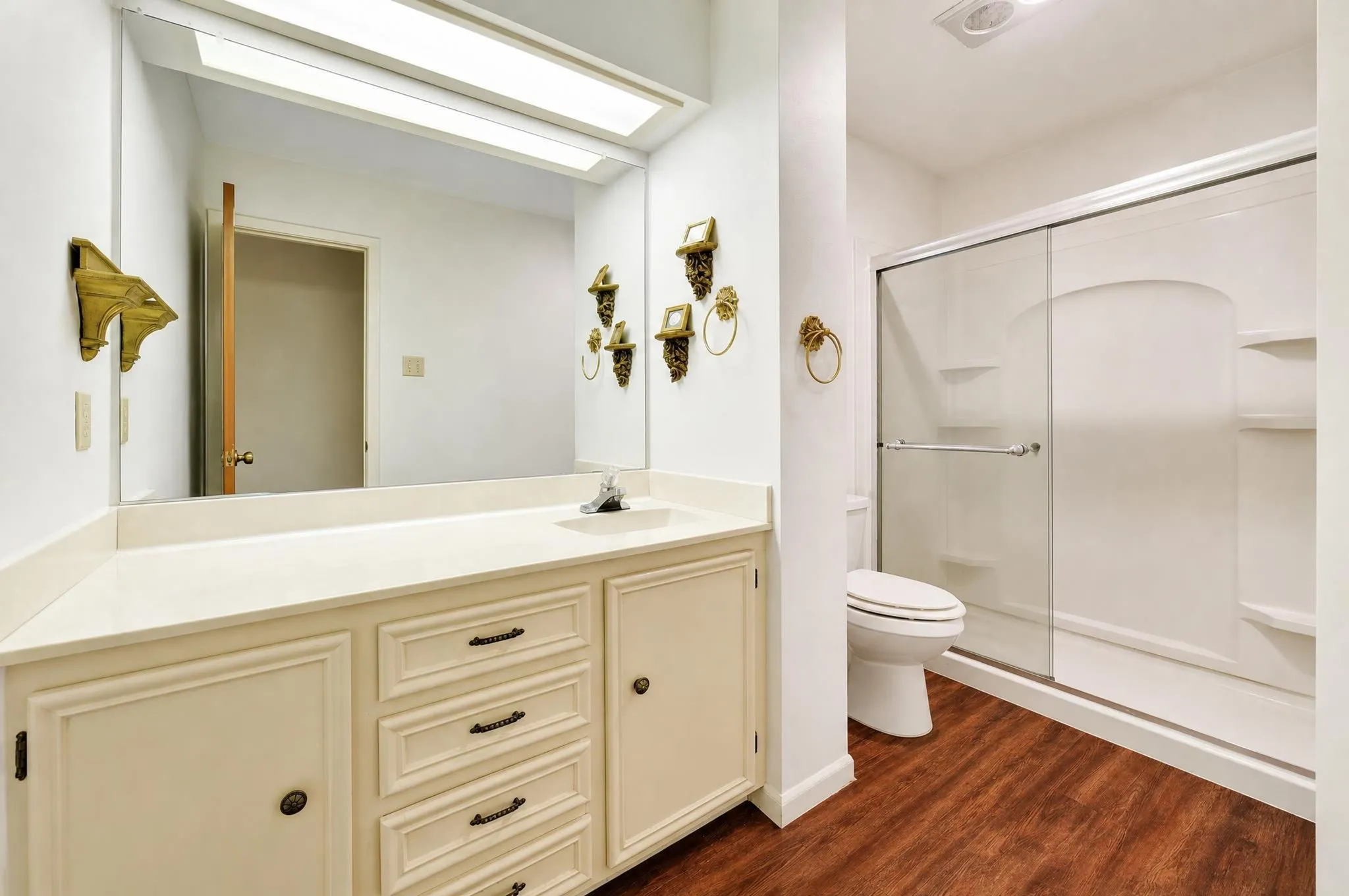 Cream-painted vanity with multiple drawers and cabinet storage, single basin sink, and an extended countertop