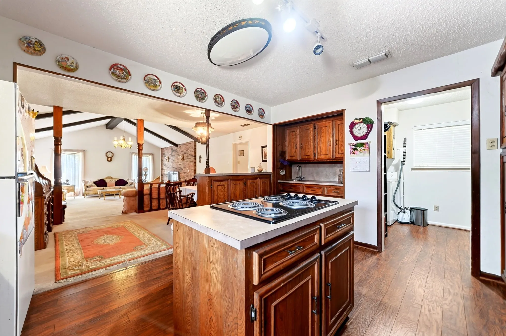 Kitchen featuring wood-finish flooring, a kitchen island with cooktop, and wood cabinetry