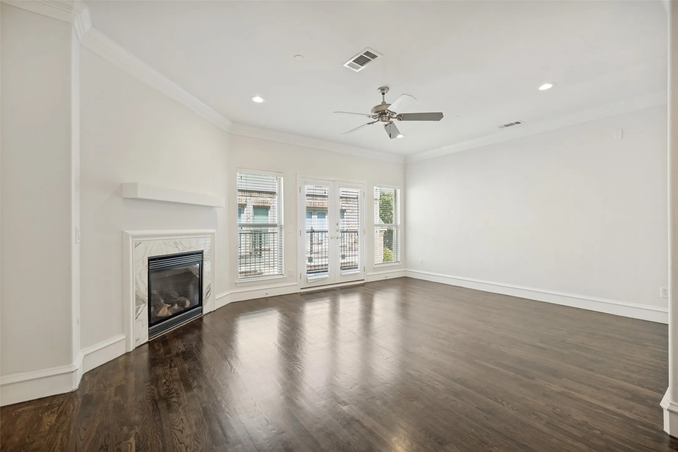 Dark wood-finish flooring, recessed lighting, and crown molding