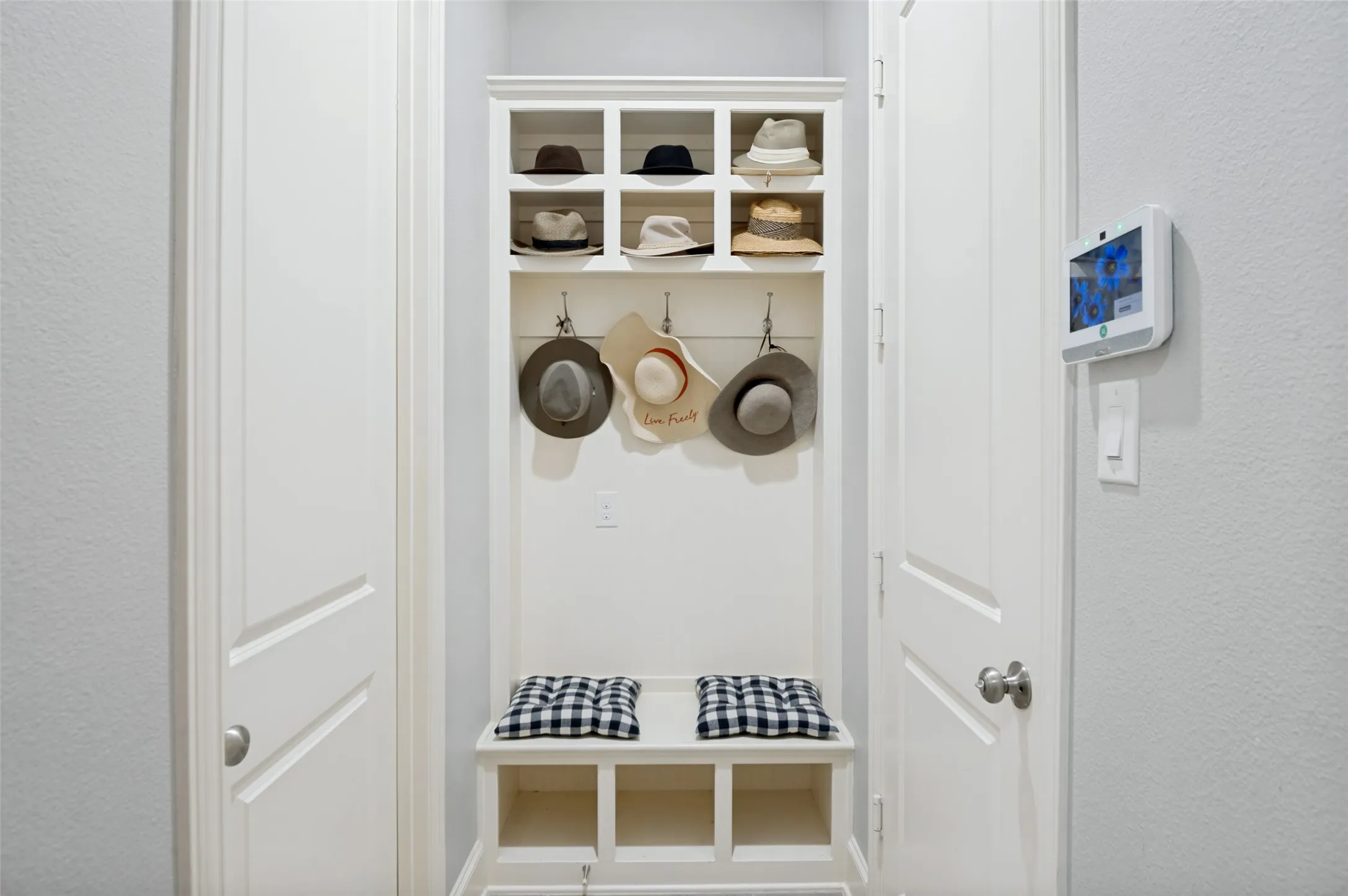 Convenient mudroom featuring built-in storage cubbies, hooks, and bench seating, providing the perfect drop zone for coats, shoes, backpacks, and everyday essentials.