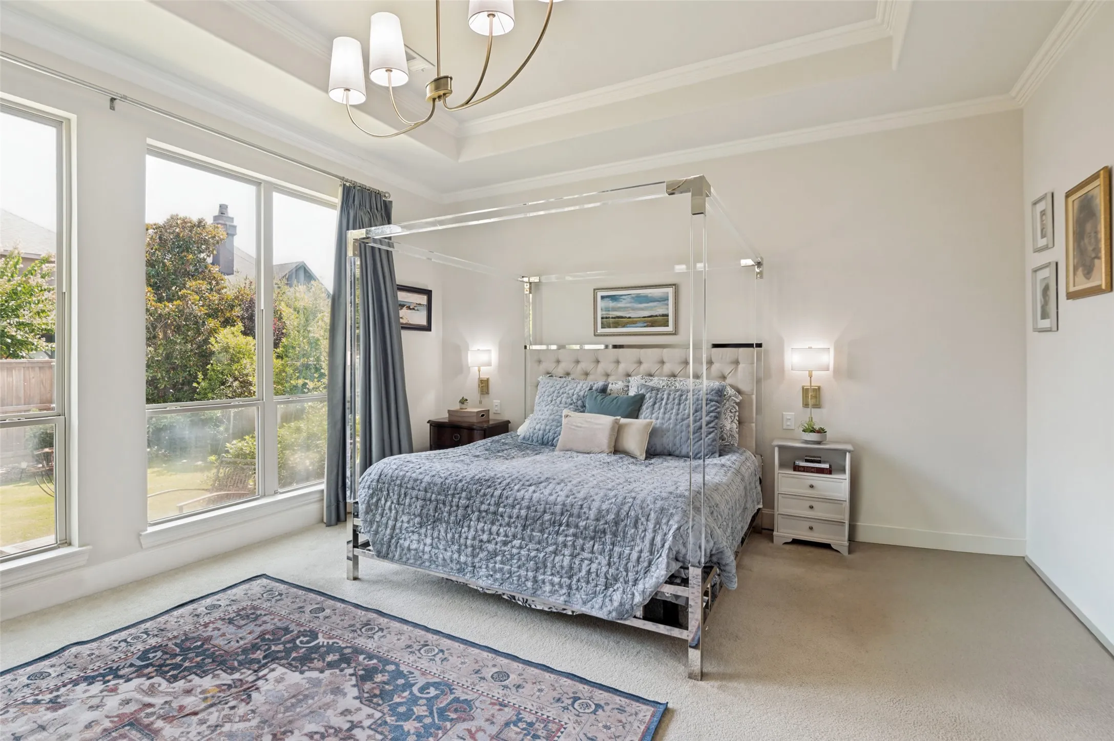 Relax in the spacious primary suite featuring large windows that fill the room with natural light, creating a peaceful retreat with plenty of space for a sitting area and elegant furnishings.
