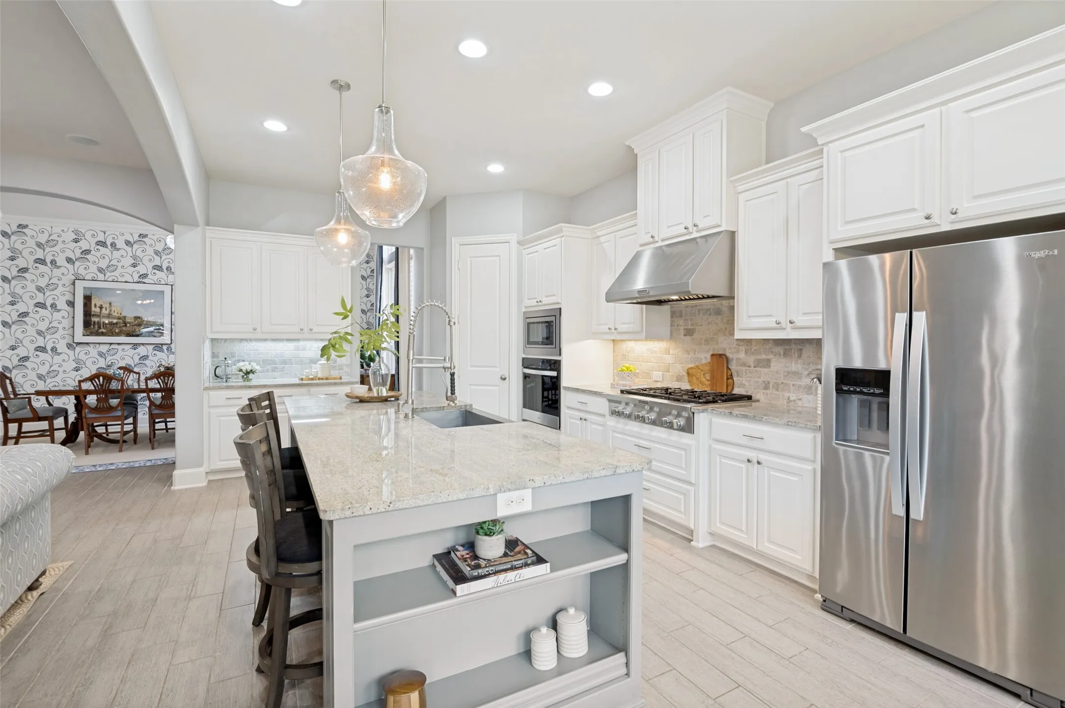 Bright, open-concept kitchen with a spacious quartz island, abundant cabinetry, designer pendant lighting, and elegant finishes. Seamlessly connected to the breakfast room and family room, this inviting space is ideal for entertaining and everyday living.