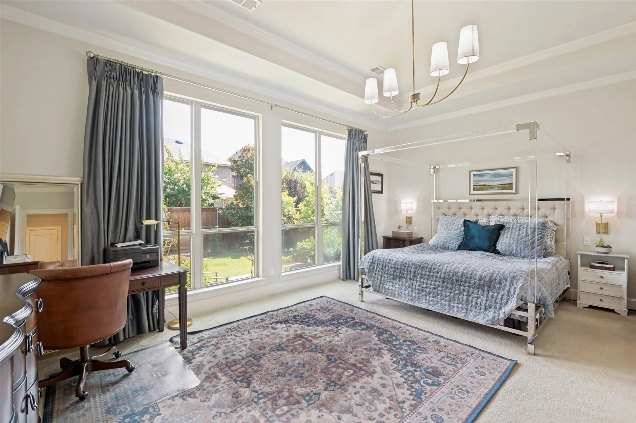 Spacious primary suite featuring a tray ceiling, abundant natural light, and oversized windows overlooking the beautifully landscaped backyard. This peaceful retreat offers plenty of room for a sitting area and direct access to the luxurious ensuite bath.