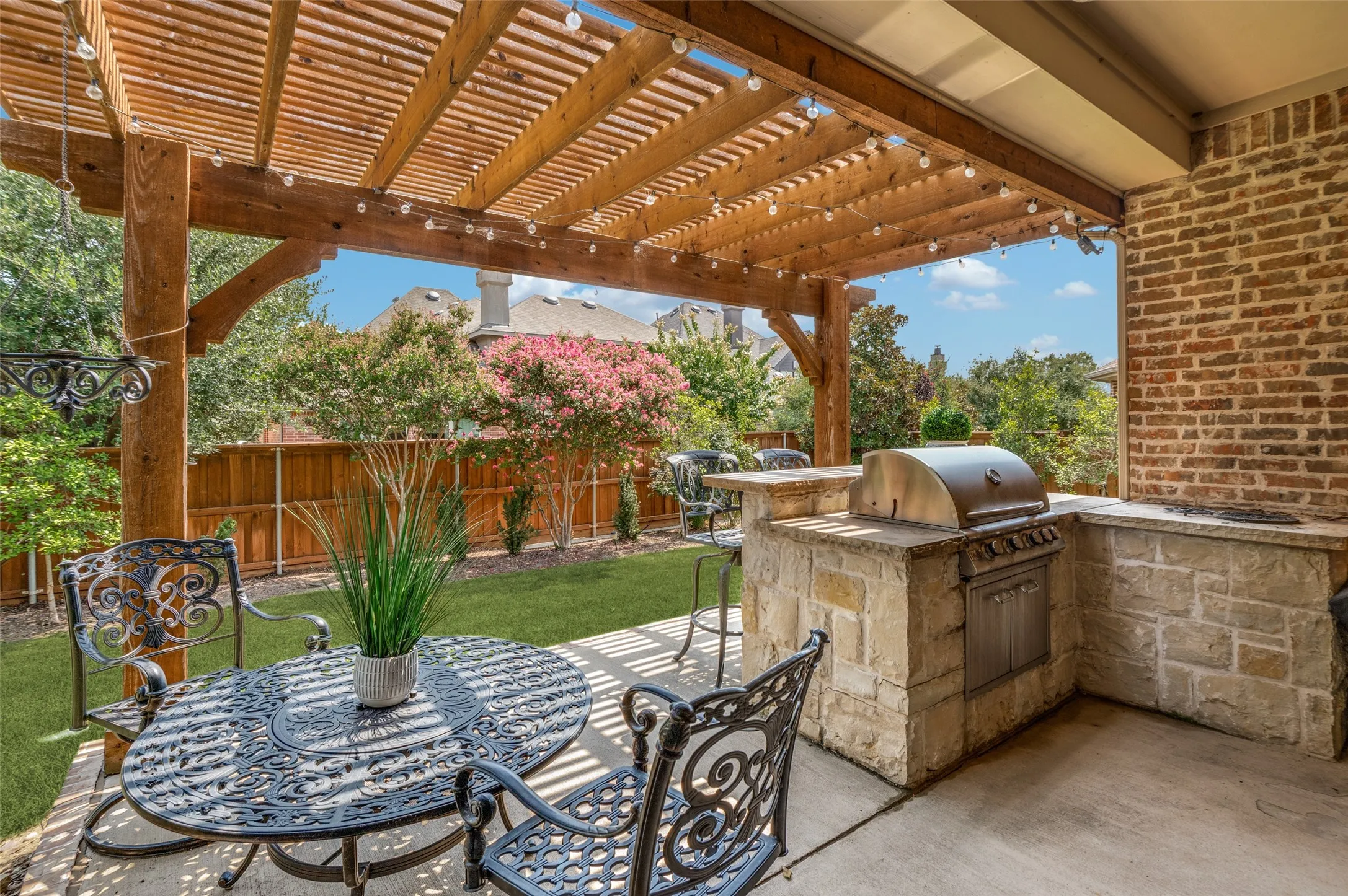 Exceptional outdoor living space featuring a custom cedar pergola, built-in outdoor  grill and bar seating, and beautifully landscaped backyard. Perfect for year-round entertaining, dining al fresco, or relaxing with family and friends.