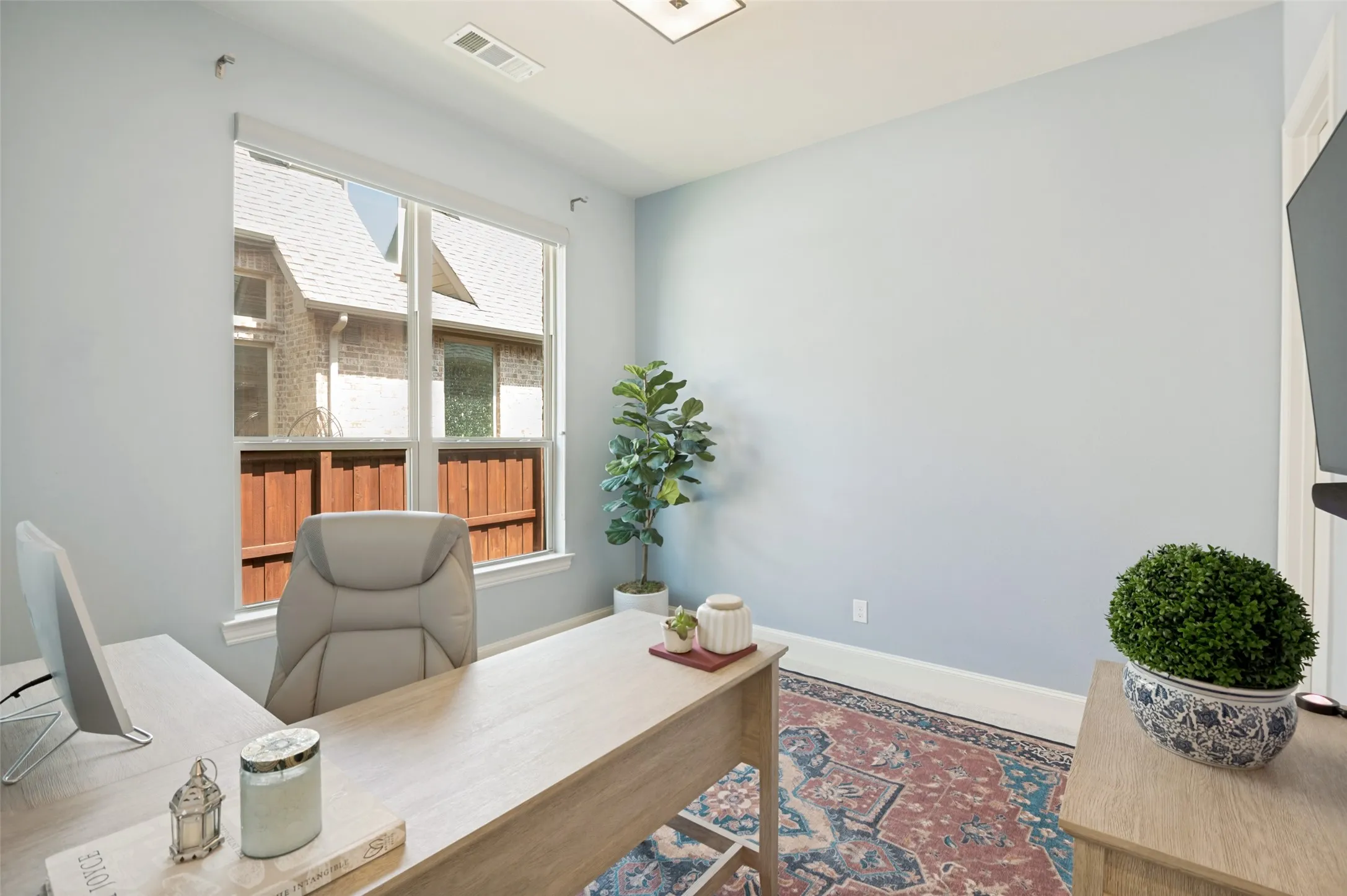 Spacious secondary bedroom with a large window that fills the room with natural light, offering a versatile space for guests, family, or a private home office.
