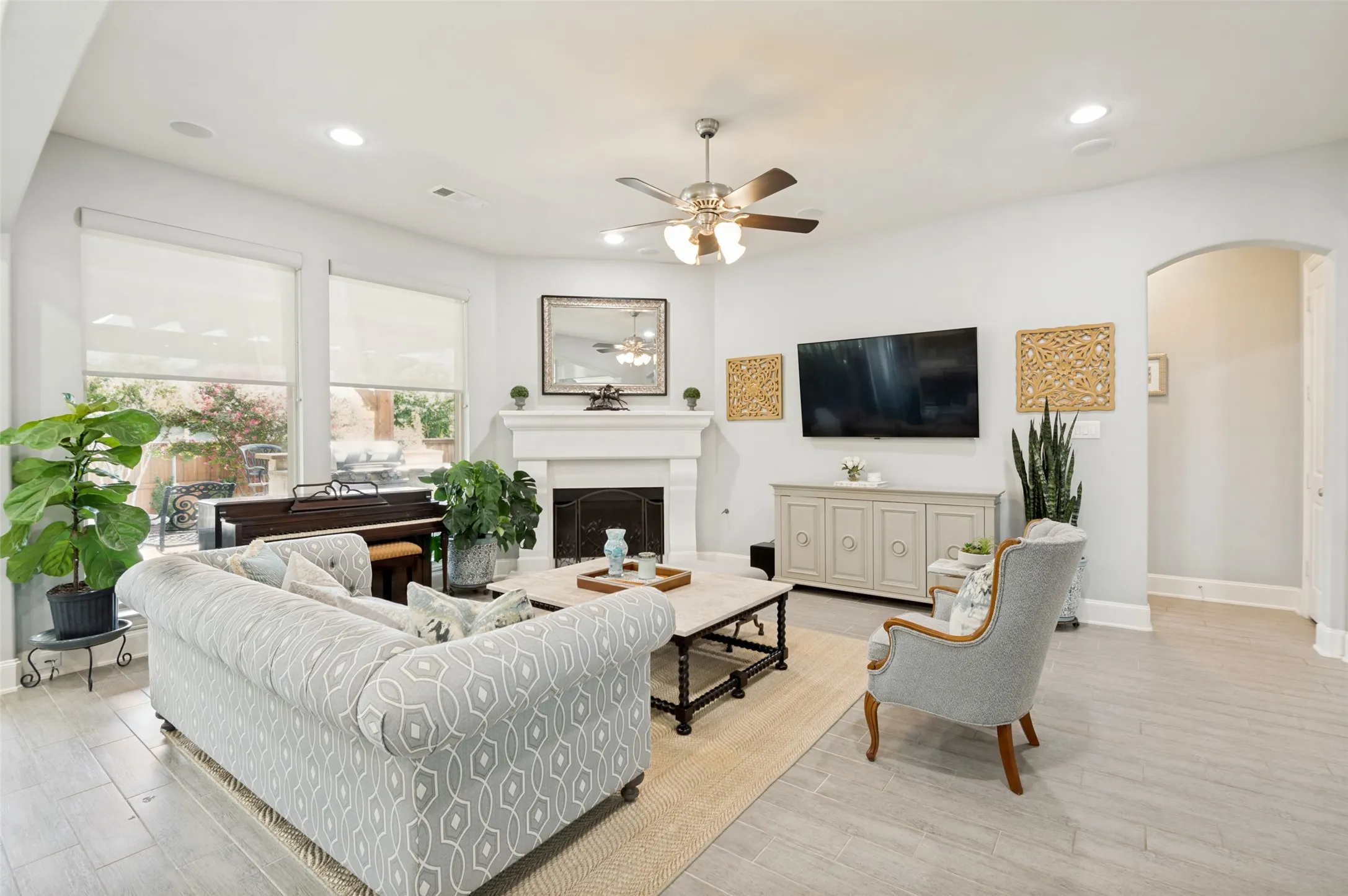 Spacious family room featuring a beautiful fireplace, abundant natural light, and an open-concept design that flows seamlessly into the kitchen and breakfast room. Large windows overlook the covered patio and beautifully landscaped backyard, creating the perfect space for relaxing or entertaining.