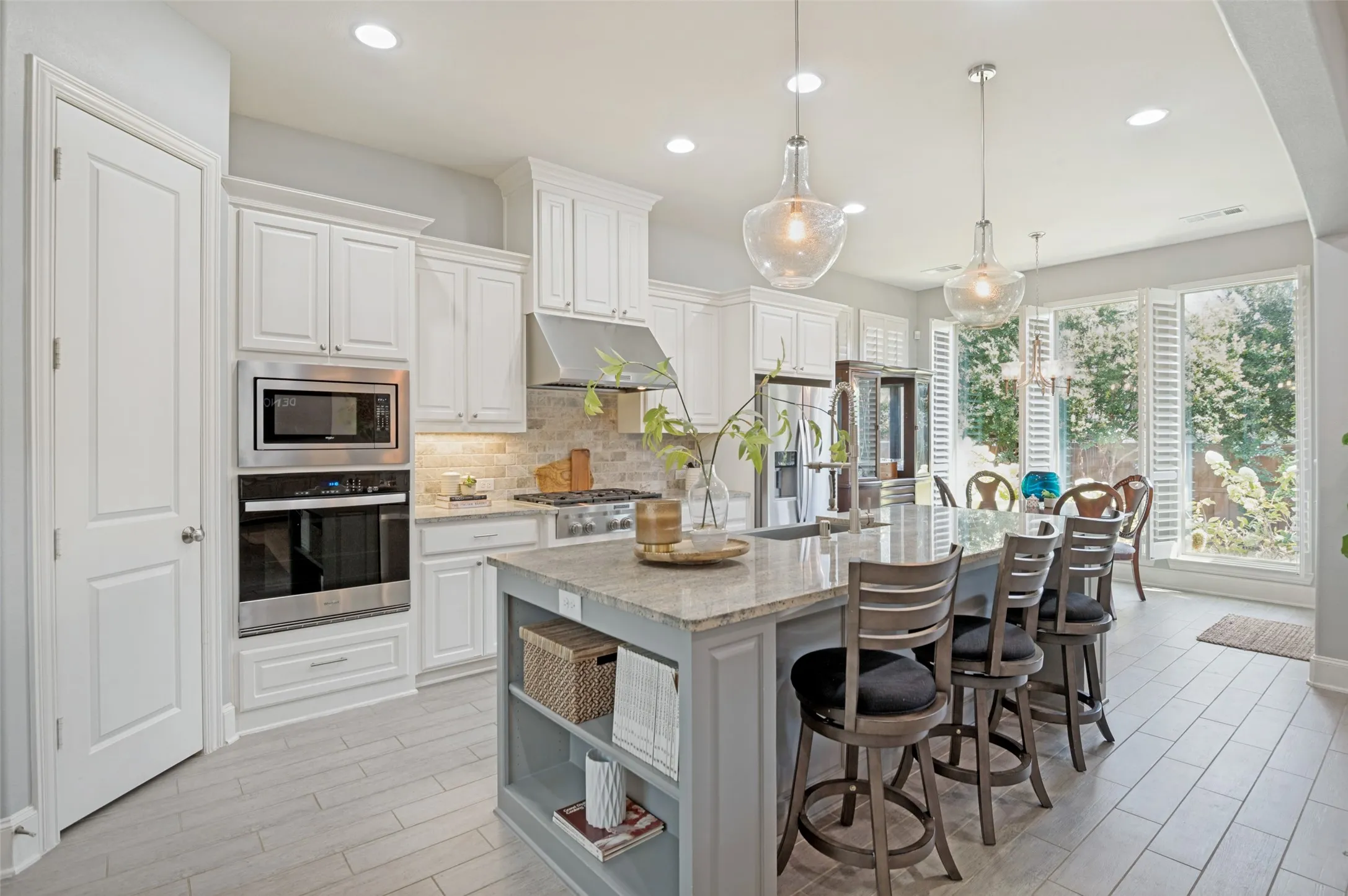 Gourmet kitchen featuring an oversized island with seating, quartz countertops, stainless steel appliances, custom cabinetry, microwave,oven, and a spacious open-concept design that flows seamlessly into the living and dining areas—perfect for everyday living and entertaining.