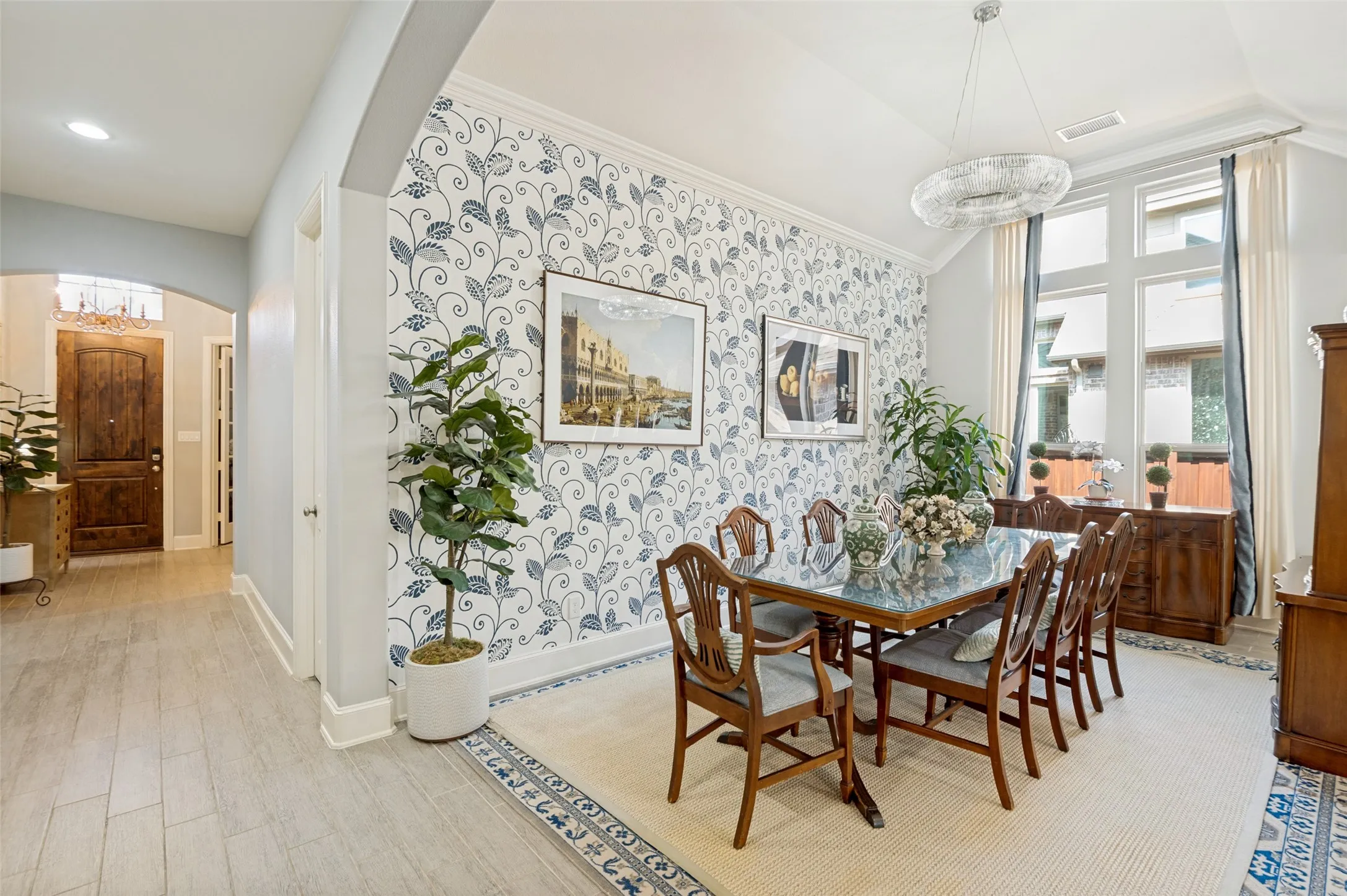 Beautiful formal dining room with soaring ceilings, decorative accent wall, and large windows. Ideally situated between the foyer and main living area, creating an open flow that's perfect for everyday living and entertaining.
