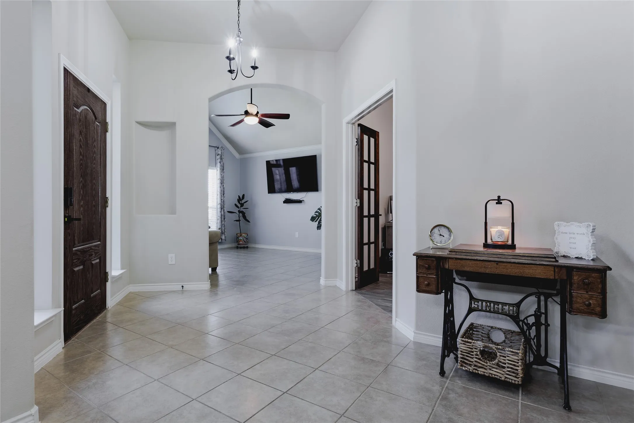 Welcoming foyer showcasing tile flooring, a ceiling fan with pendant lighting, and dark wood entry doors
