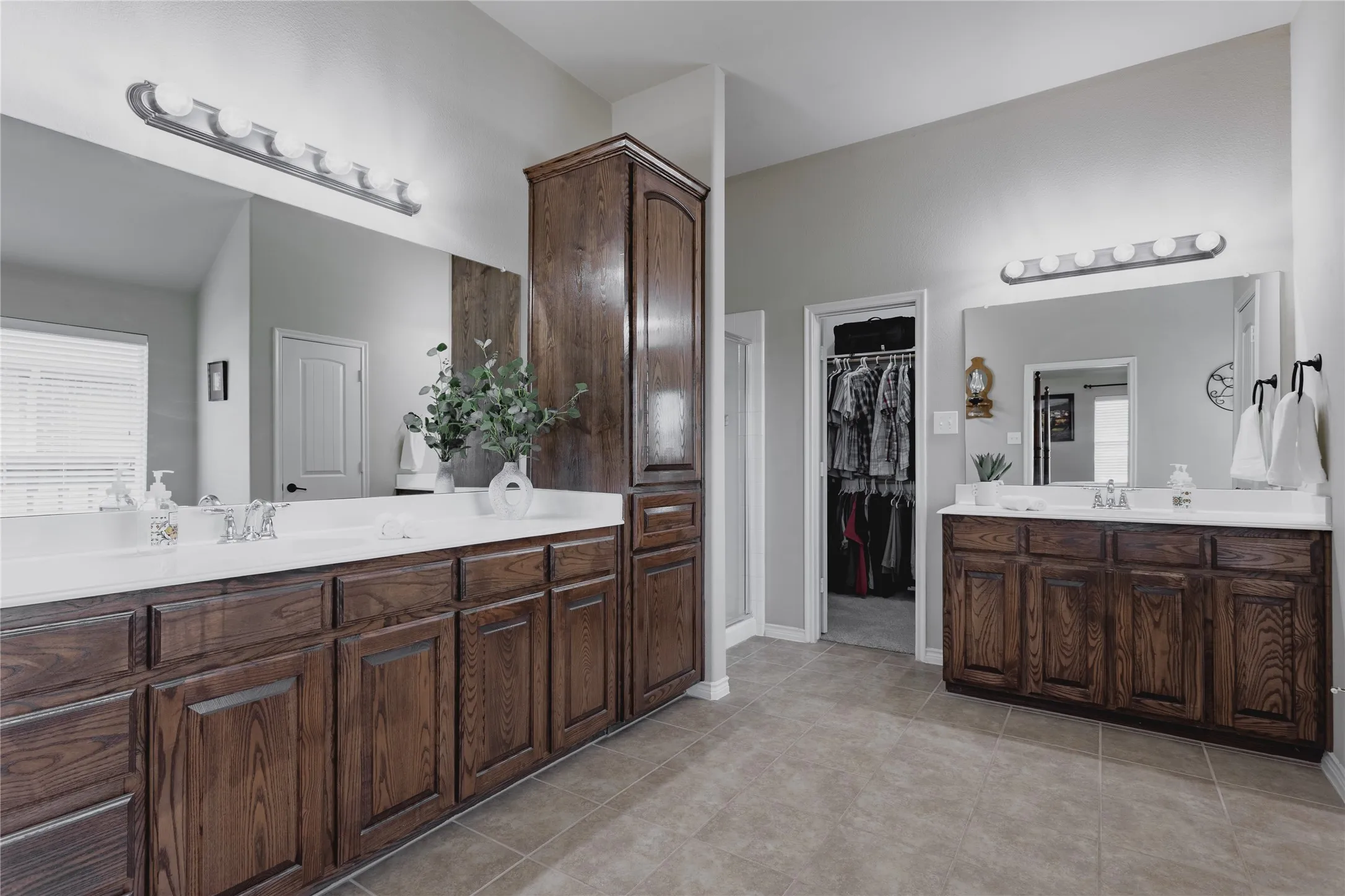 Dual vanities with white countertops, expansive mirrors, and wood-finish​​‌​​​​‌​​‌‌​‌‌​​​‌‌​‌​‌​‌​​​‌​​ cabinetry
