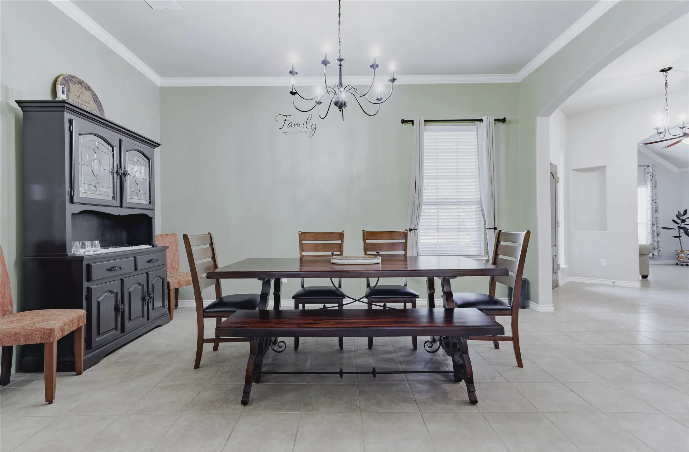 Spacious room with crown molding, chandelier lighting, and tile flooring