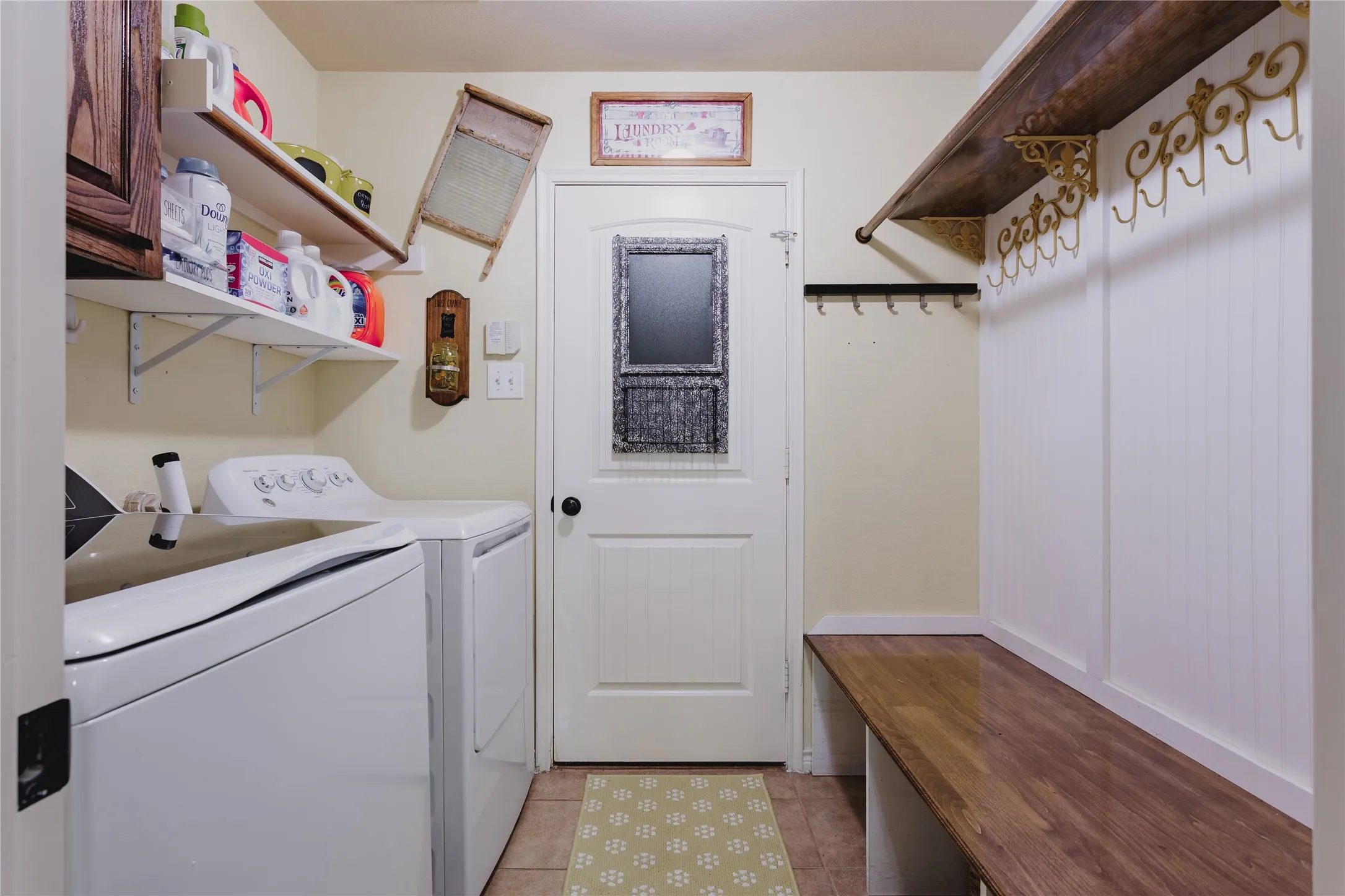 Utility space featuring a wood-finish bench, beadboard wainscoting, and a built-in shelf with decorative brackets