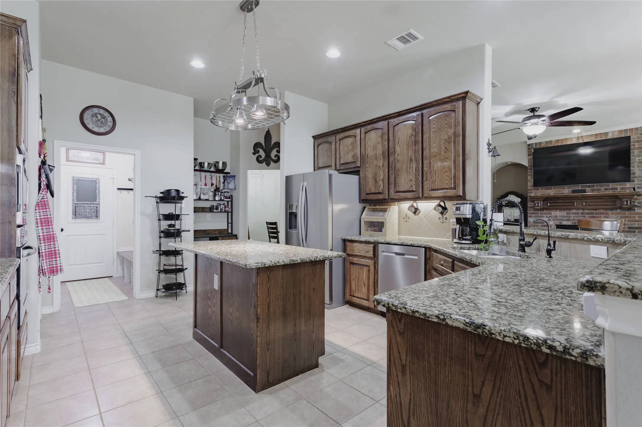 Kitchen featuring a central island with granite countertops, stainless steel appliances, and wood cabinetry