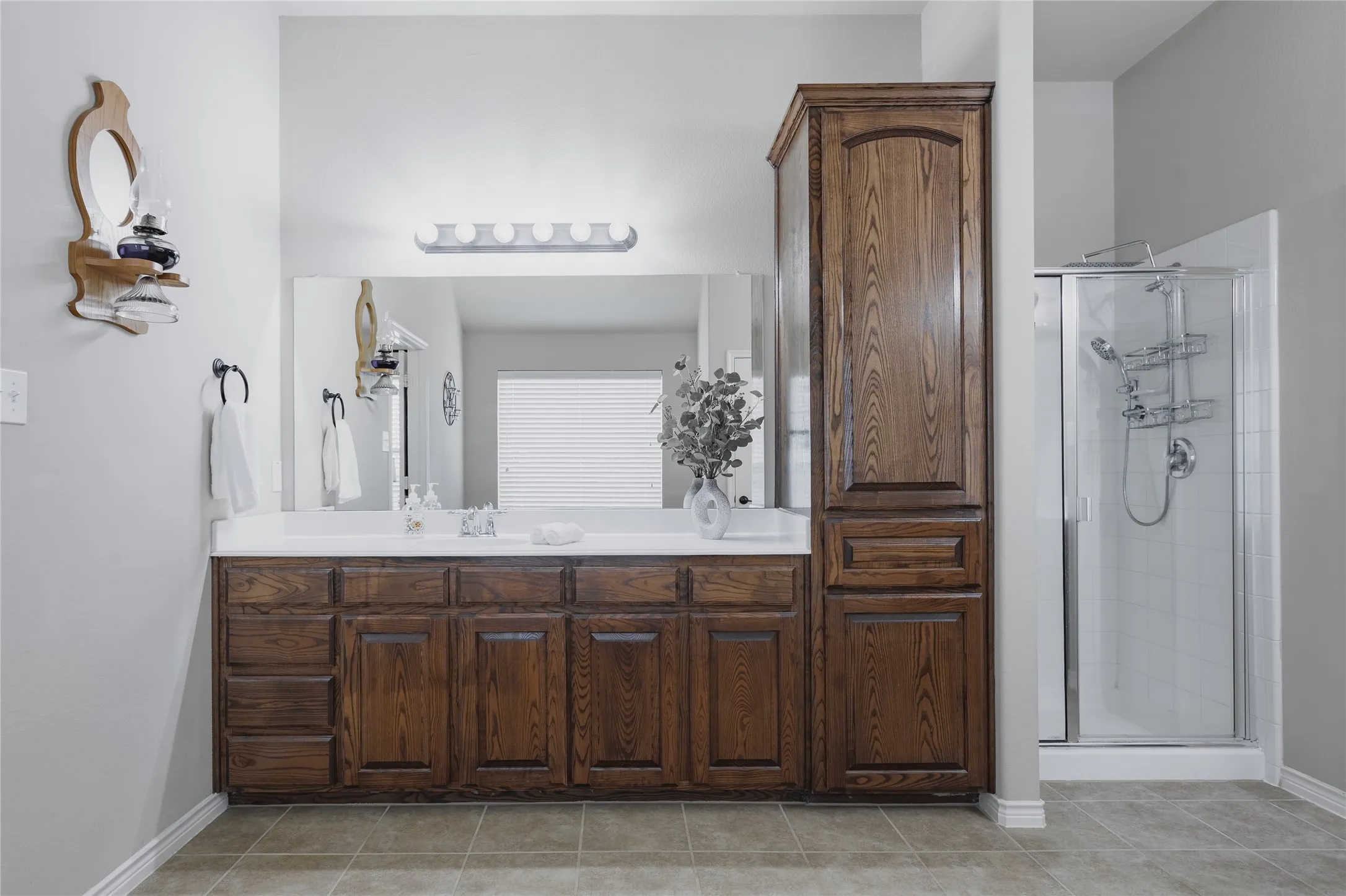 Dual vanity with wood-finish cabinetry, integrated sinks, and ample counter space