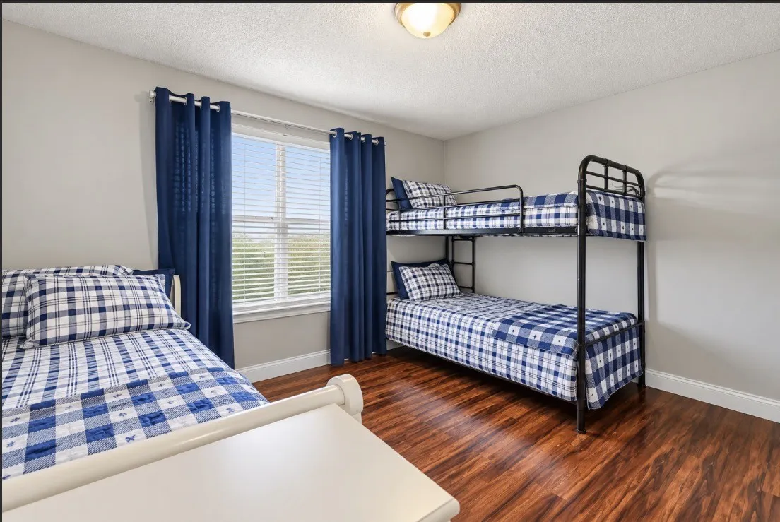 Hardwood-finish flooring, light neutral wall paint, window with blinds, and flush mount ceiling light