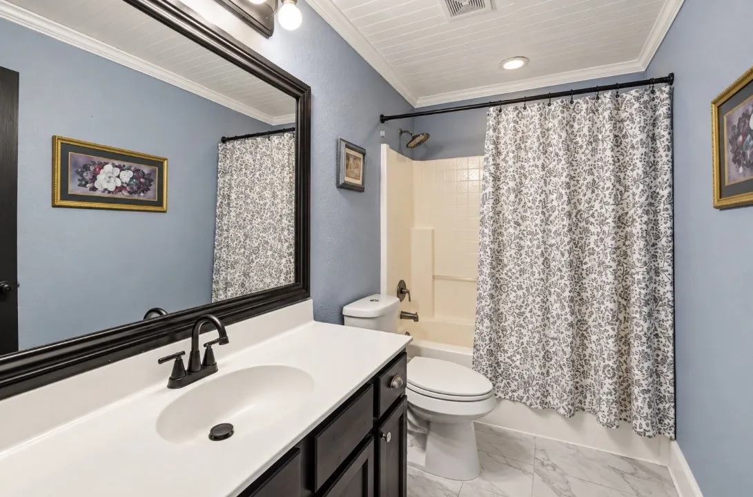 Spacious vanity with an integrated sink, dark wood-finish cabinetry, and a framed mirror