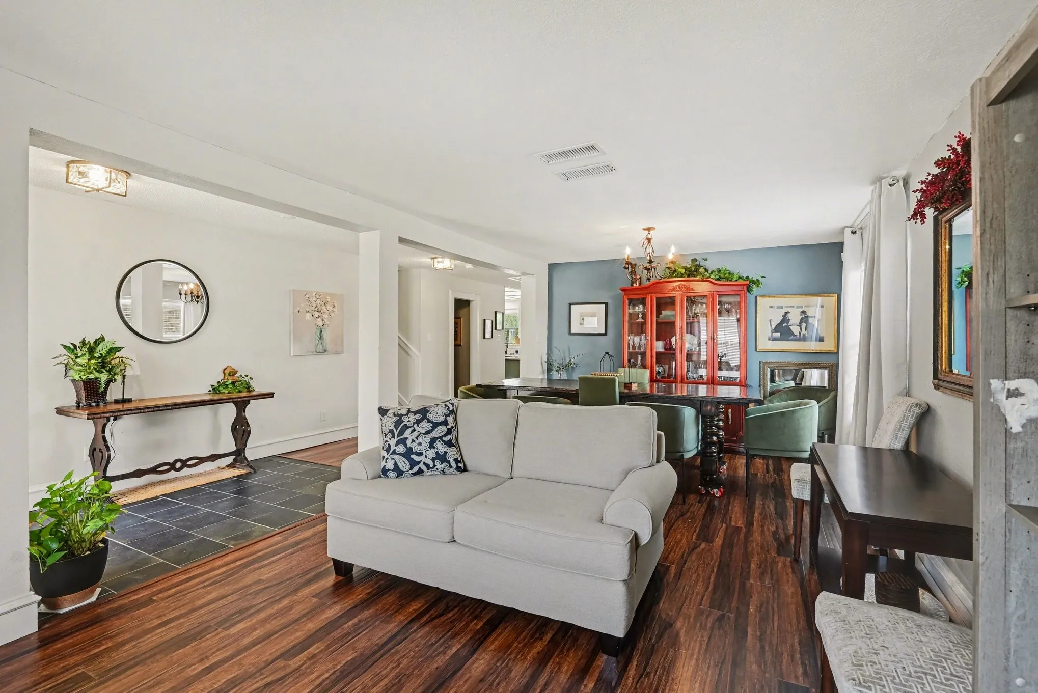 Hardwood-finish flooring, recessed lighting, and a chandelier illuminate this open-concept living space