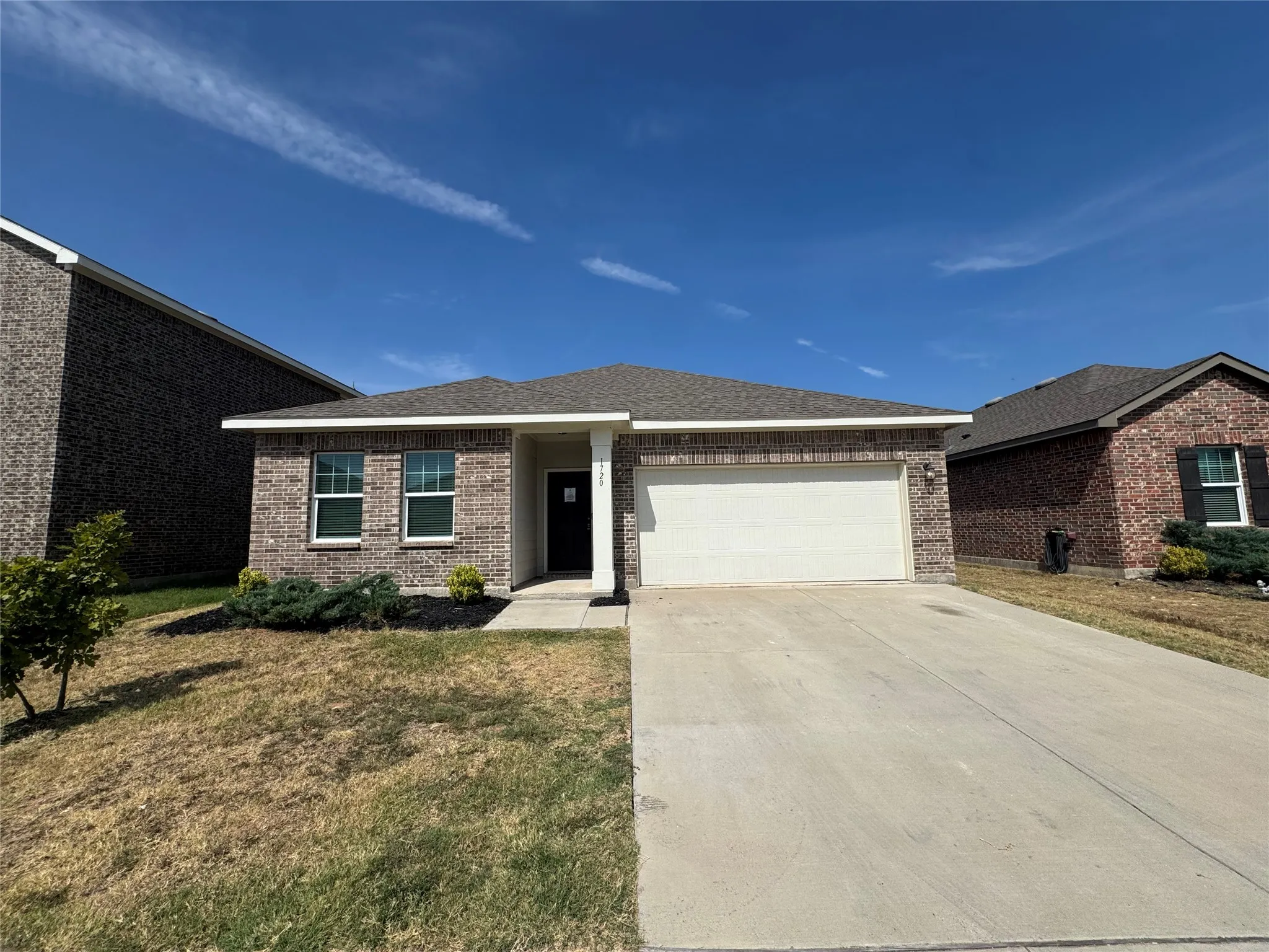 Brick exterior with a gabled roof and attached garage