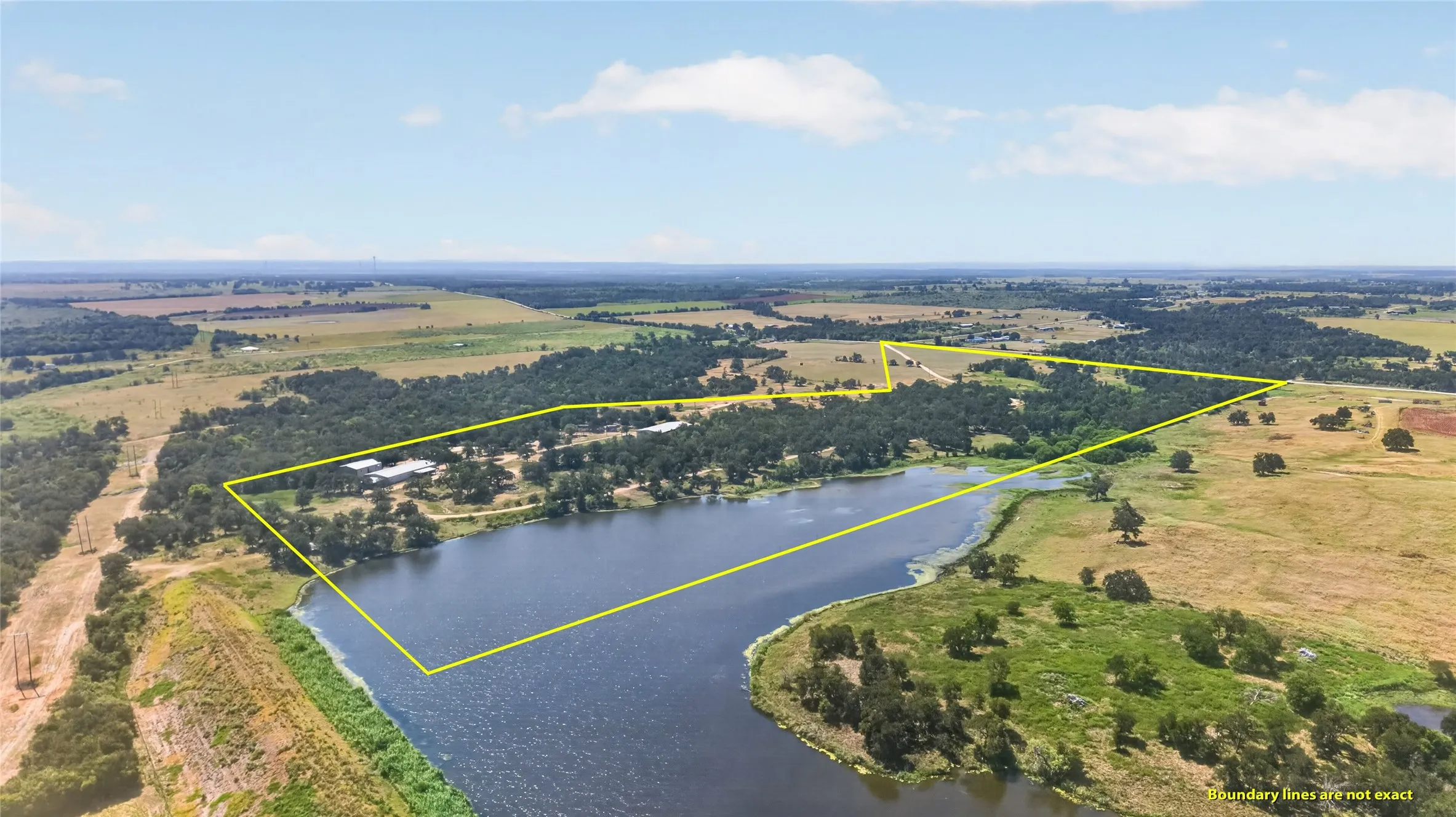 Expansive property featuring a large body of water, extensive wooded areas, and open fields