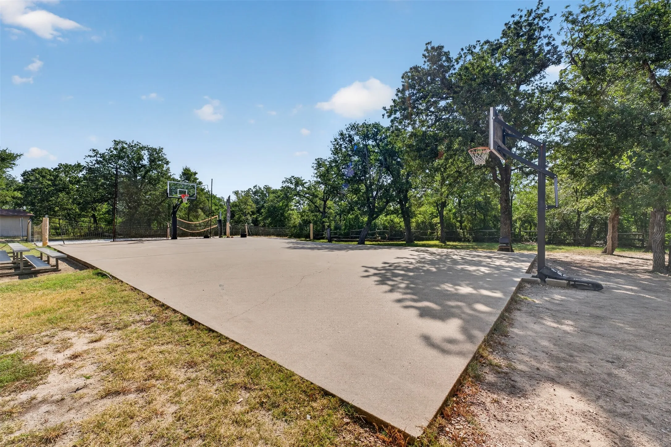 Dedicated outdoor recreation court with professional-grade playing surface, multiple basketball hoops, and sturdy metal posts