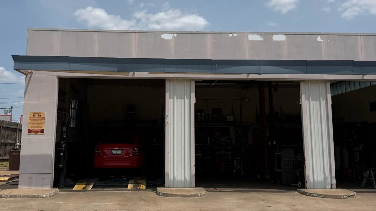 Commercial building with three service bays featuring overhead doors and concrete entry ramps