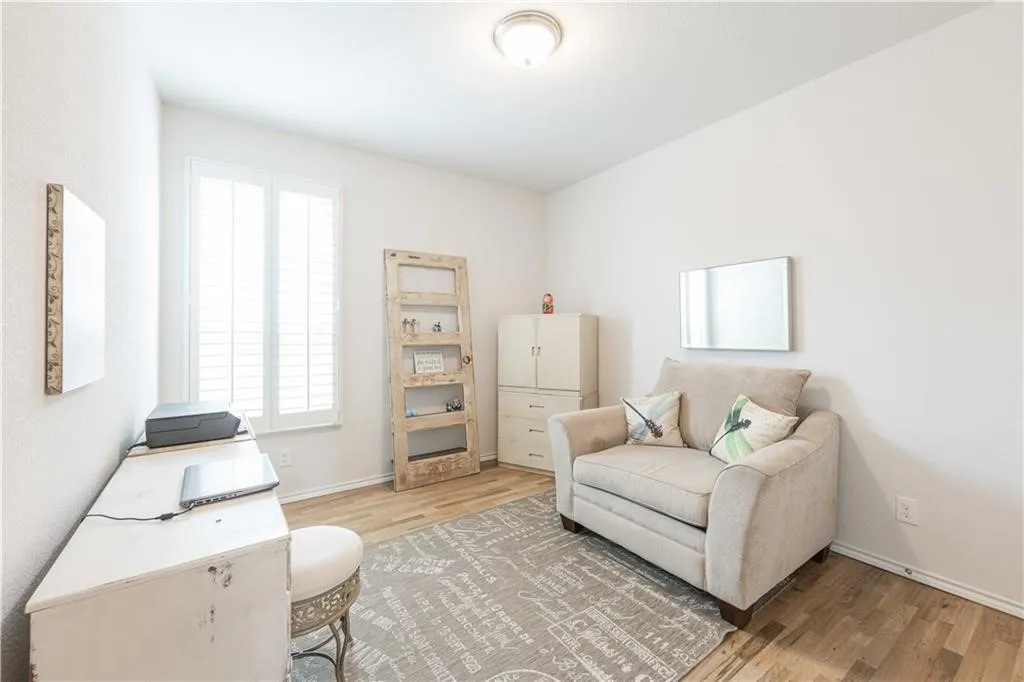 Bright, light-filled bedroom featuring hardwood flooring, recessed ceiling lighting, and dual windows with plantation shutters