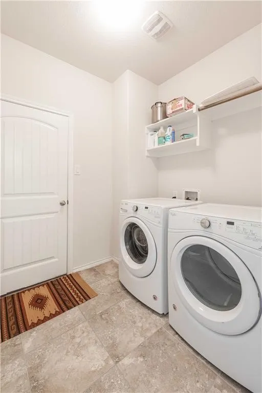 Laundry area featuring tile flooring, built-in shelving, and a clothing rod