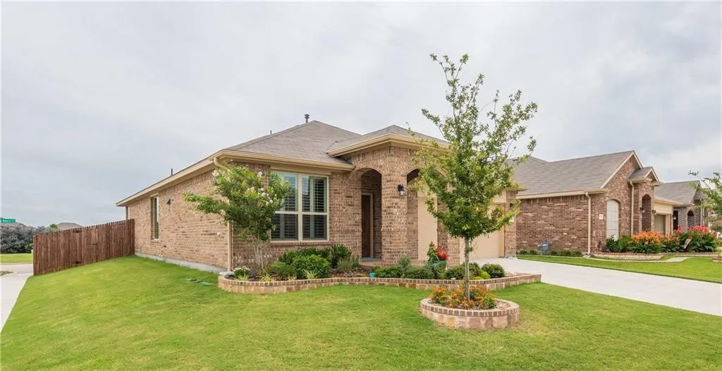 Brick exterior home featuring a curved architectural entry, arched doorway, and large front-facing windows